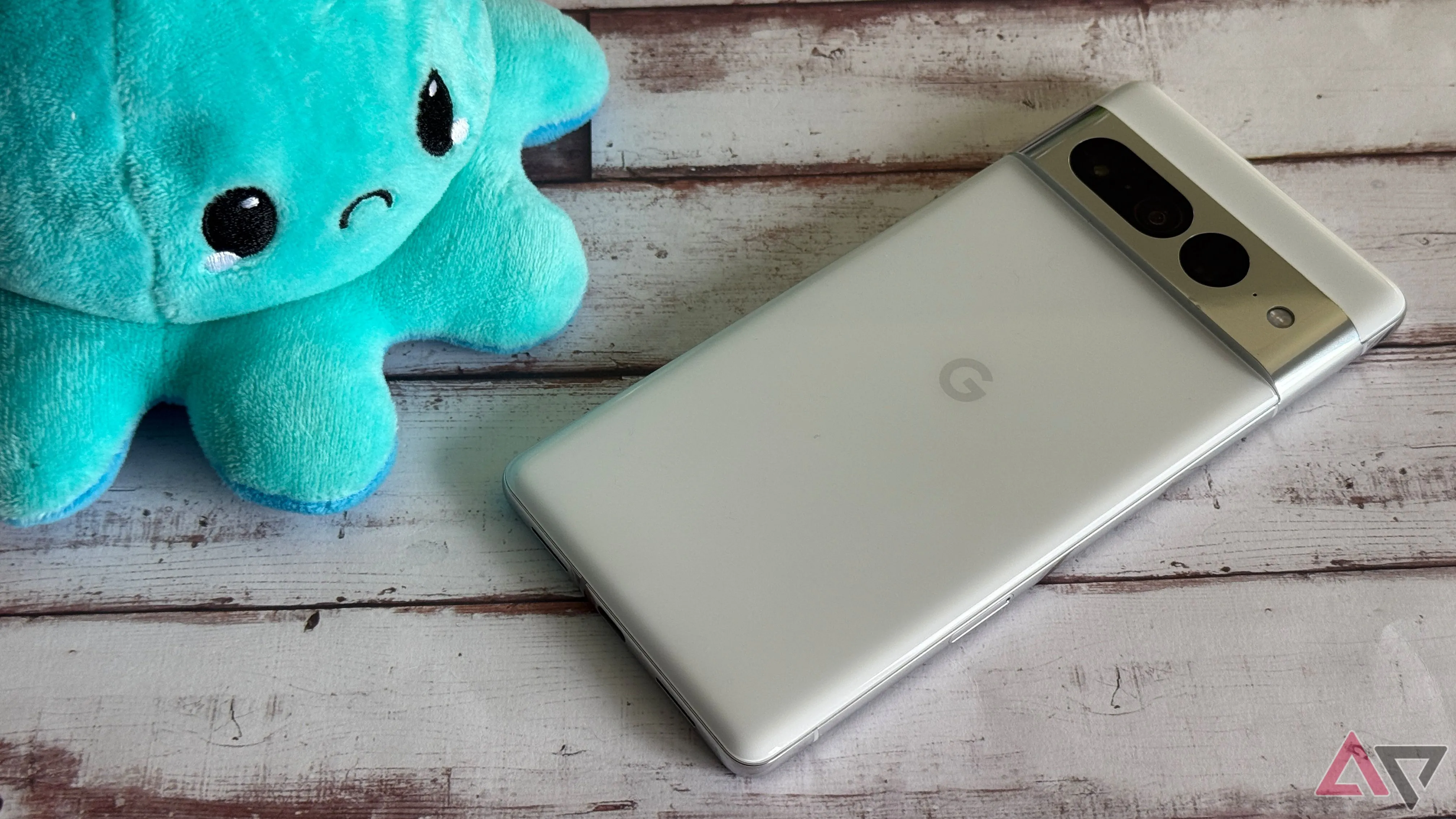 Điện thoại Google Pixel 7 Pro đặt cạnh đồ chơi mặt cau có, thể hiện sự thất vọng với hiệu năng của máy.