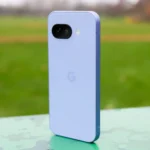 Điện thoại Google Pixel 9a màu tím đứng trong công viên, thể hiện thiết kế mặt lưng độc đáo.