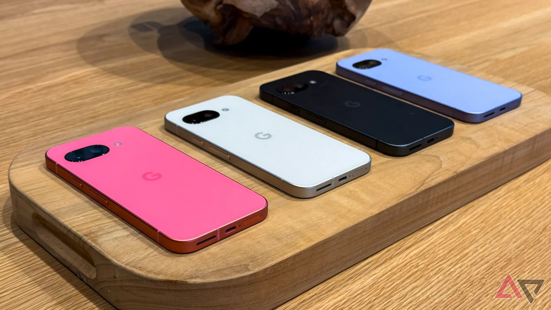 Điện thoại Google Pixel 9a với bốn tùy chọn màu sắc khác nhau đặt úp trên mặt bàn.