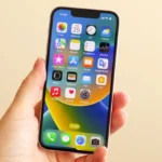 Điện thoại iPhone 13 Mini trong tay người phụ nữ, minh họa sự nhỏ gọn và dễ cầm nắm.