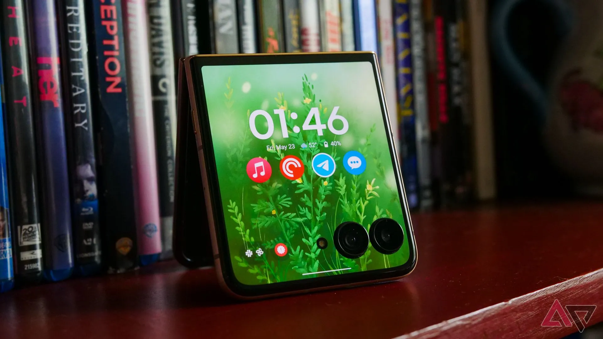 Điện thoại Motorola Razr Ultra 2025 hiển thị màn hình ngoài trên kệ sách