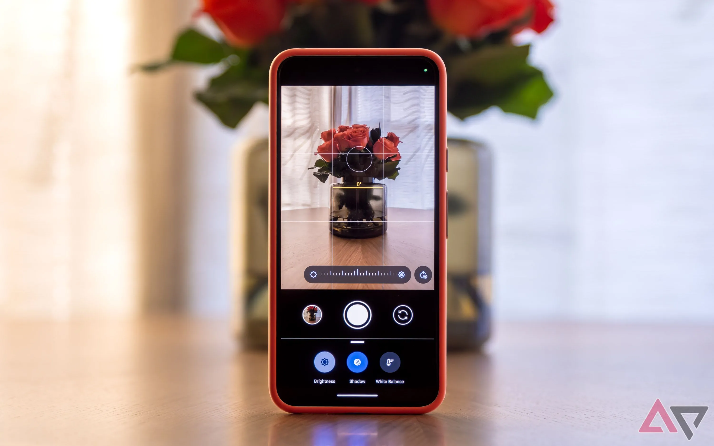 Giao diện ứng dụng Camera trên điện thoại Pixel đặt thẳng đứng trên bàn với bình hoa, minh họa đường hiển thị của tính năng Framing Hints giúp căn chỉnh ảnh.