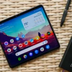 Google Pixel Fold đặt trên bàn gỗ cùng sổ và bút