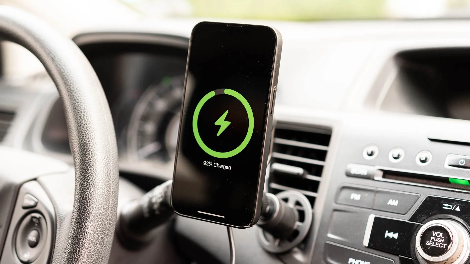 iPhone đang sạc trên giá đỡ sạc không dây mophie gắn cửa gió ô tô.