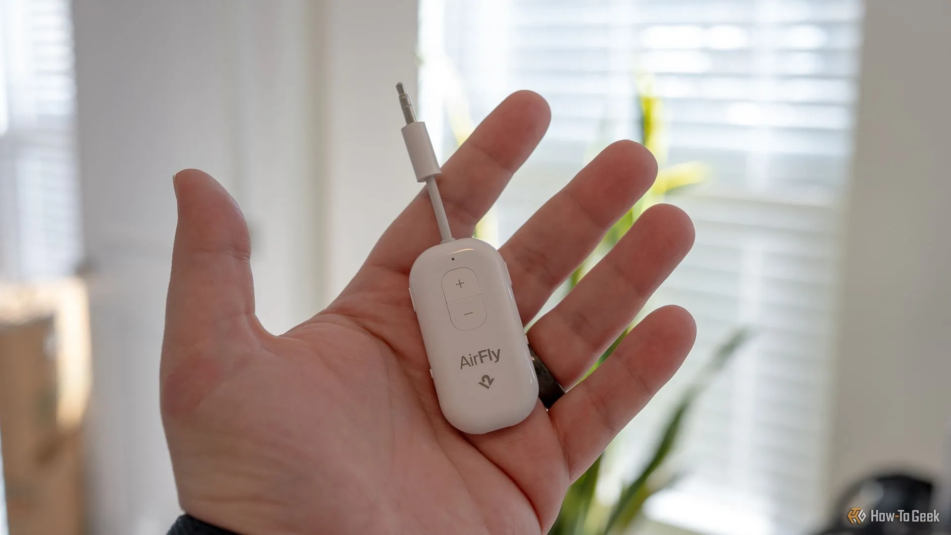 Người dùng cầm bộ phát âm thanh Bluetooth AirFly Pro 2, gadget tiện lợi cho giải trí khi du lịch.