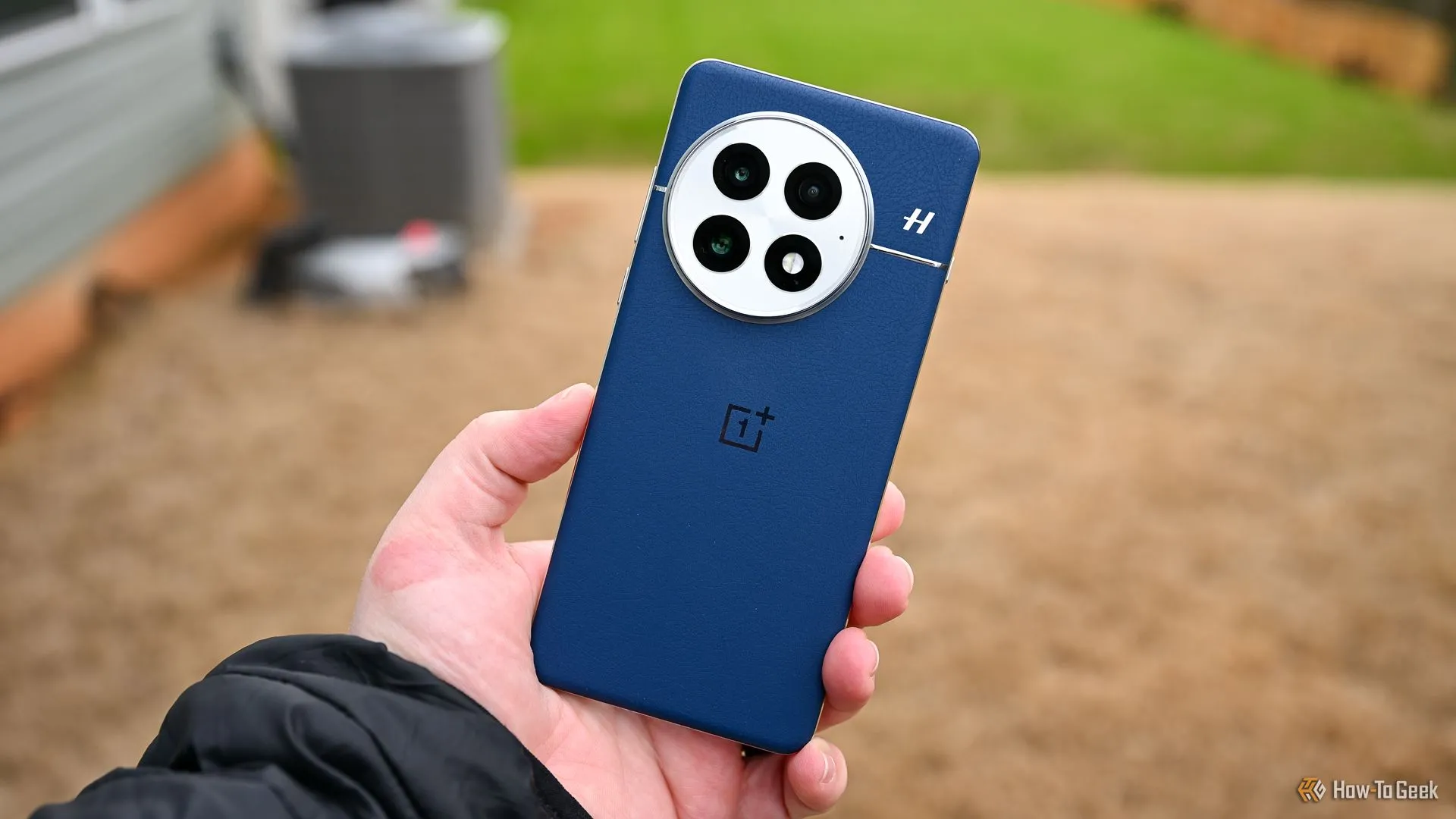 Người dùng cầm điện thoại OnePlus 13 màu xanh, cho thấy mặt lưng và cụm camera, là một trong những mẫu sử dụng công nghệ pin mới.