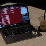 MacBook cùng AirPods trên giường, thể hiện phong cách làm việc hiện đại