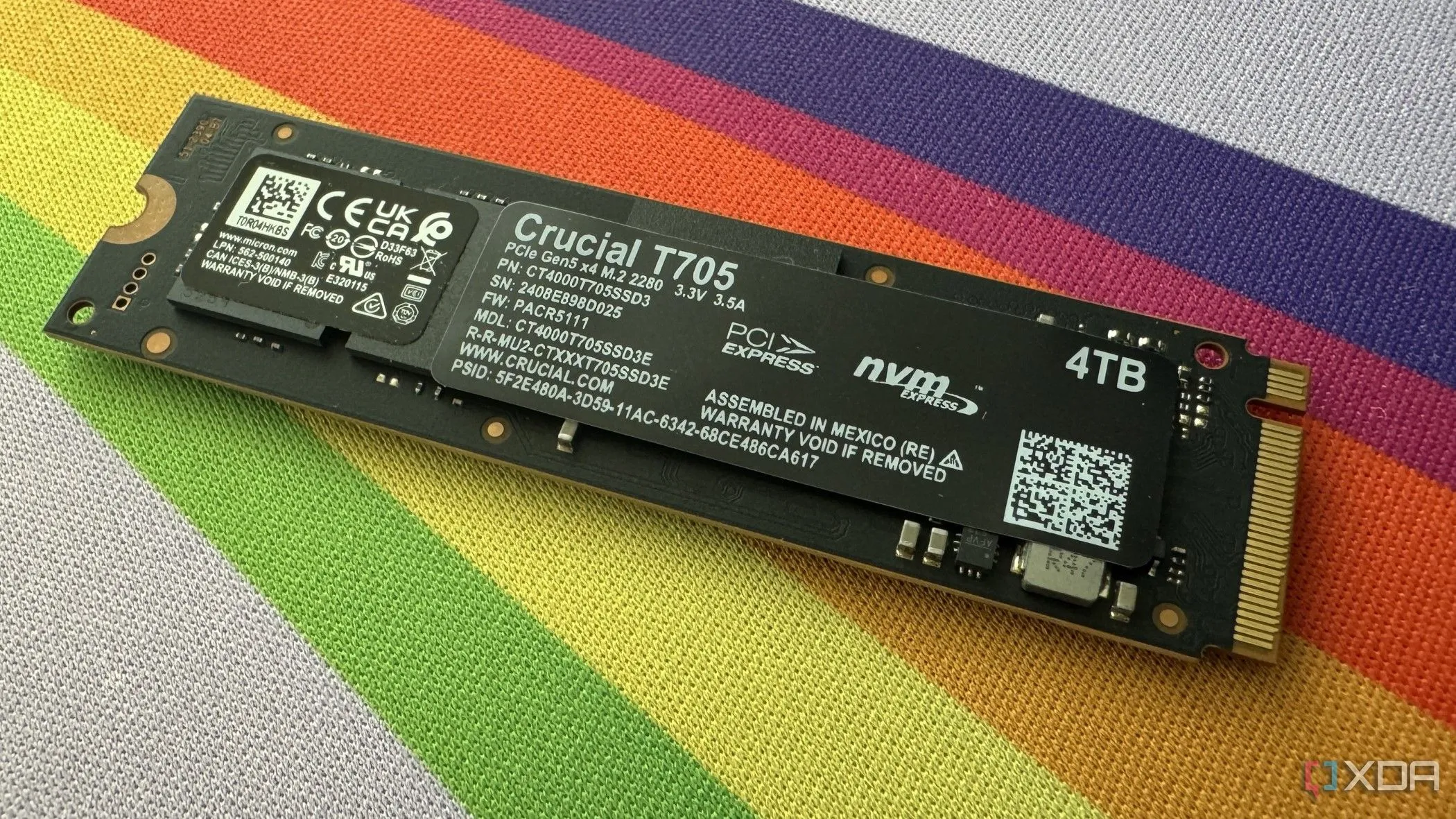 Mặt sau của ổ cứng Crucial T705 SSD với nhãn thông số kỹ thuật, nhấn mạnh tầm quan trọng của việc kiểm tra thông tin và firmware của thiết bị.