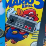 Một bộ điều khiển NES bản sao cho Nintendo Switch trên đỉnh các áp phích cho nhiều trò chơi Mario khác nhau