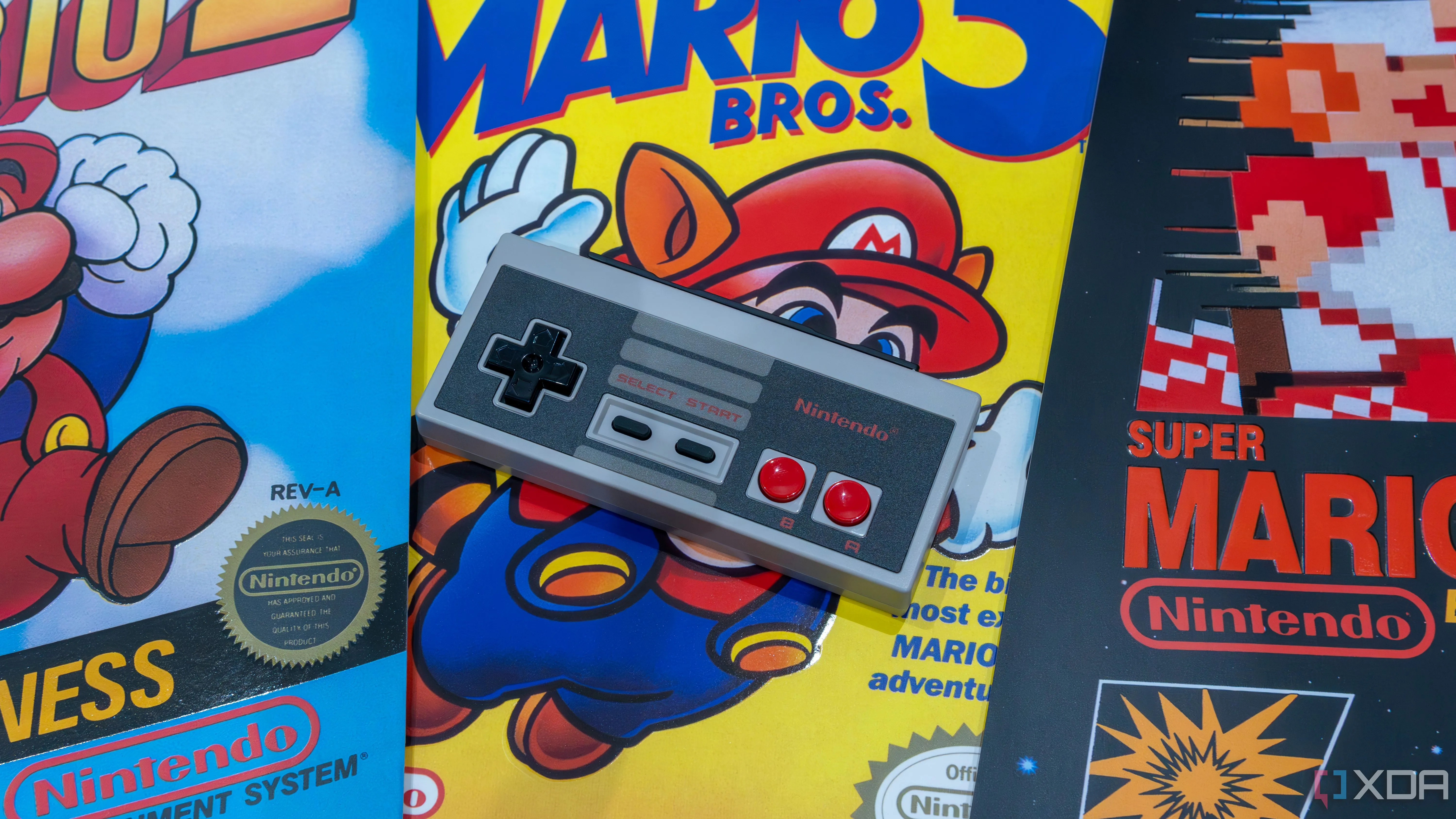 Một bộ điều khiển NES bản sao cho Nintendo Switch trên đỉnh các áp phích cho nhiều trò chơi Mario khác nhau
