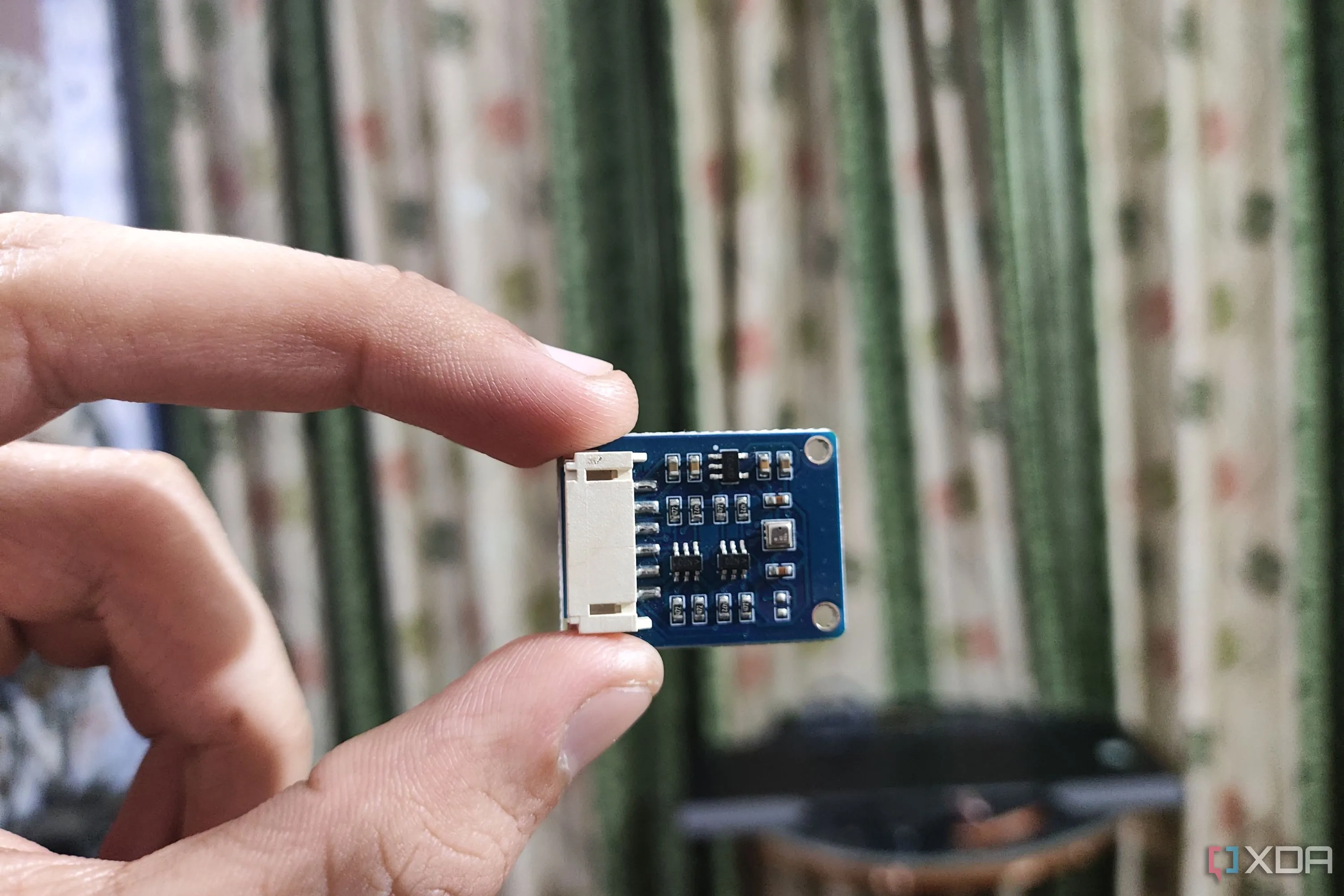 Một người đang cầm cảm biến BME280, thiết bị được dùng để thu thập dữ liệu nhiệt độ và độ ẩm cho hệ thống điều khiển khí hậu thông minh.