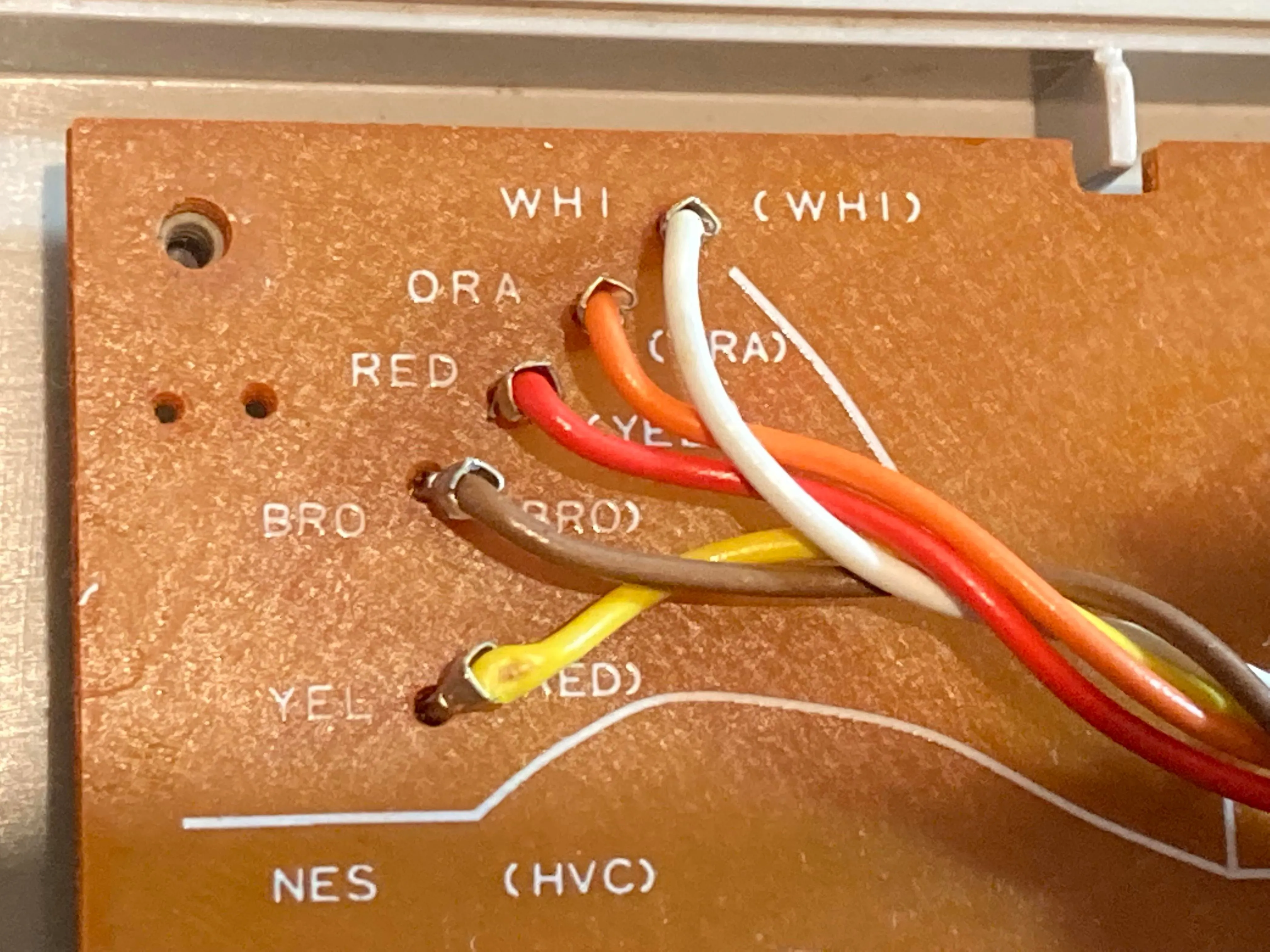 Ảnh cận cảnh các điểm kết nối dây trên bảng mạch PCB của tay cầm NES, thể hiện sự đơn giản và hiệu quả của hệ thống dây 5 màu