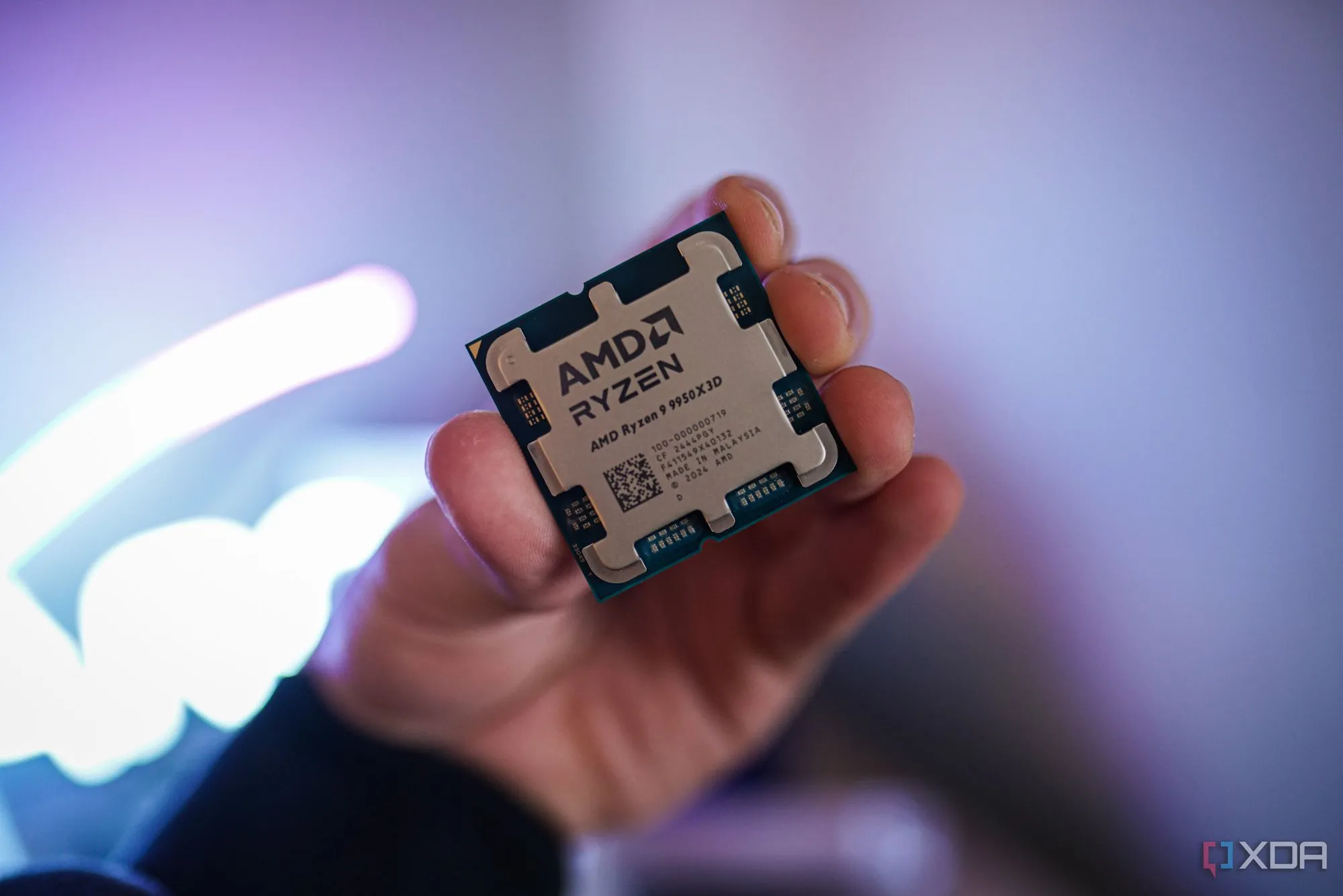 Bàn tay cầm CPU AMD Ryzen 9 9950X3D, tượng trưng cho việc đánh giá số nhân CPU có cần thiết cho nhu cầu chơi game.