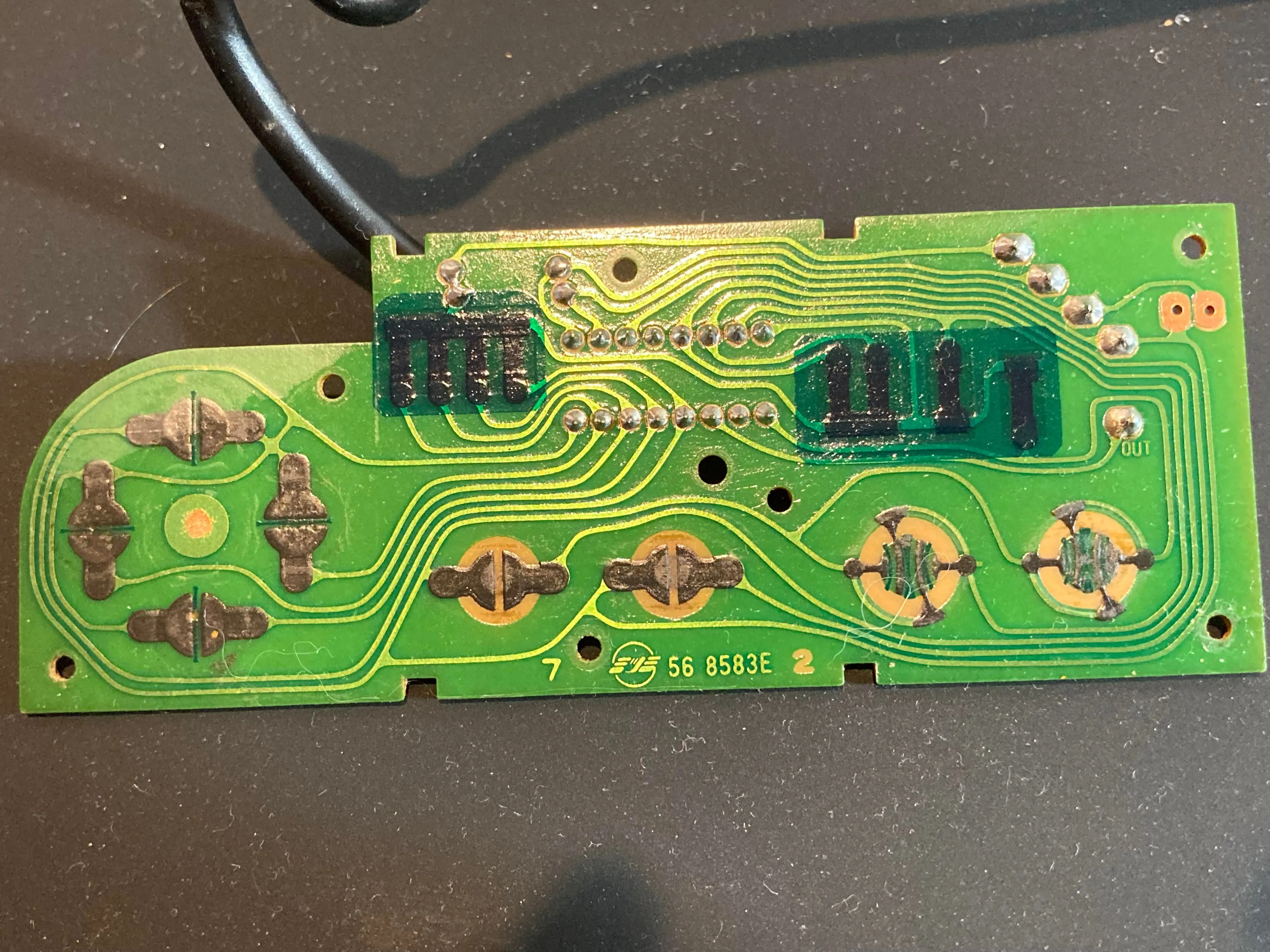 Bảng mạch in (PCB) phía trước bên trong tay cầm NES, hiển thị các điểm tiếp xúc nút và chip shift register BU4021B