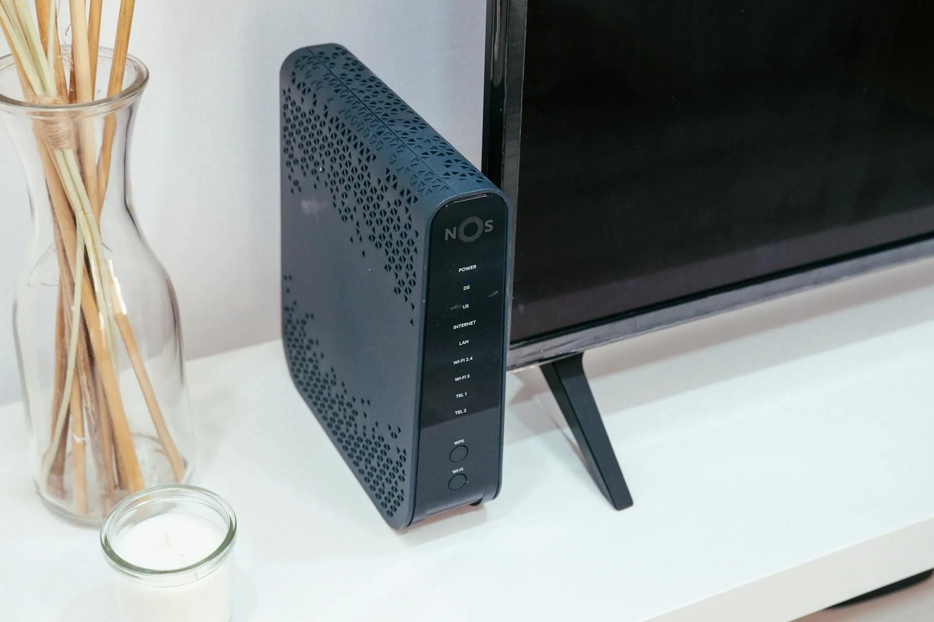 Bộ định tuyến internet được đặt cạnh tivi trong không gian gia đình, thể hiện điểm cuối của kết nối FTTH hoặc FTTC.