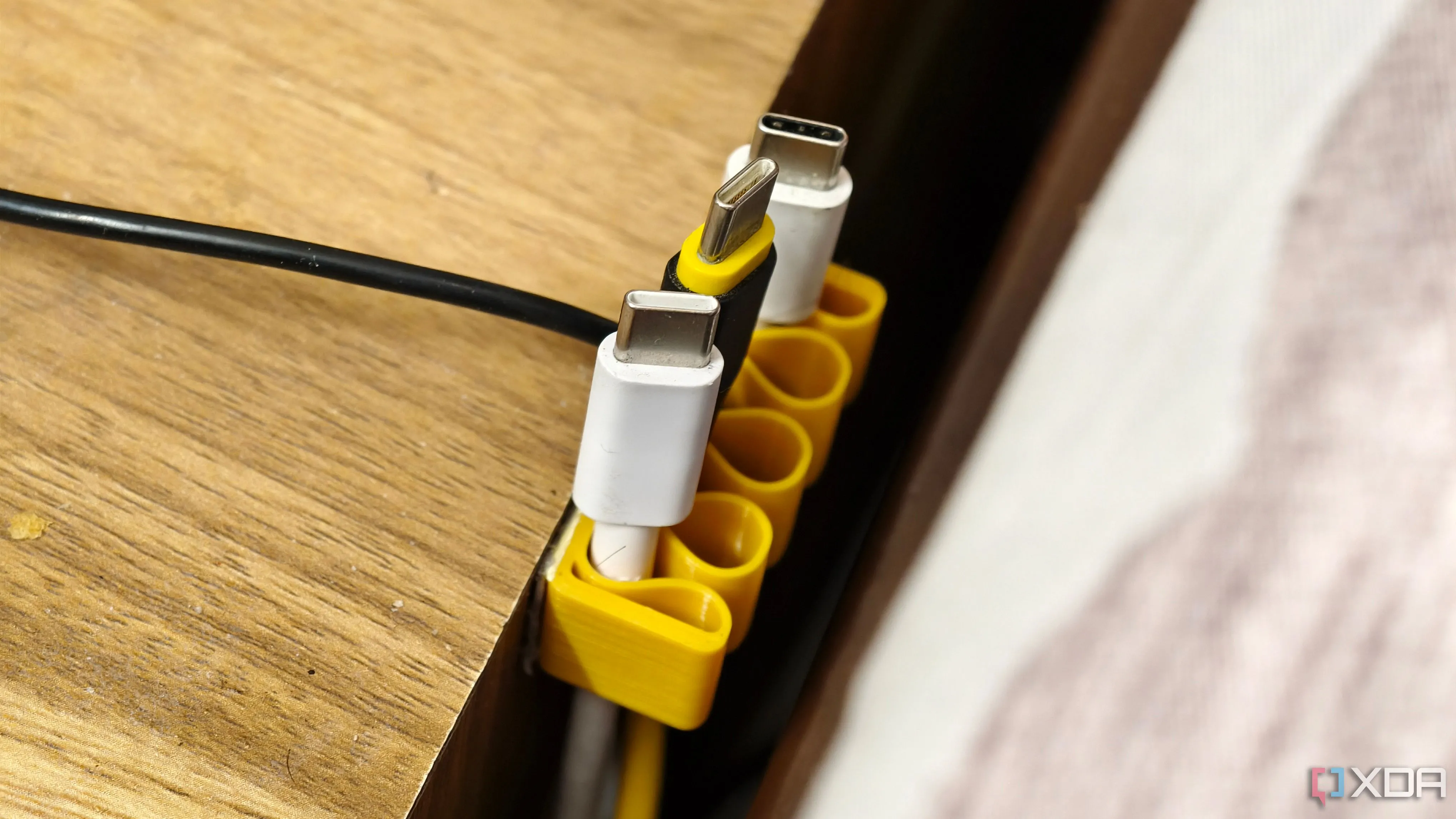 Bộ giữ cáp in 3D màu trắng gắn trên bàn, giúp cố định và sắp xếp dây cáp điện thoại, tai nghe