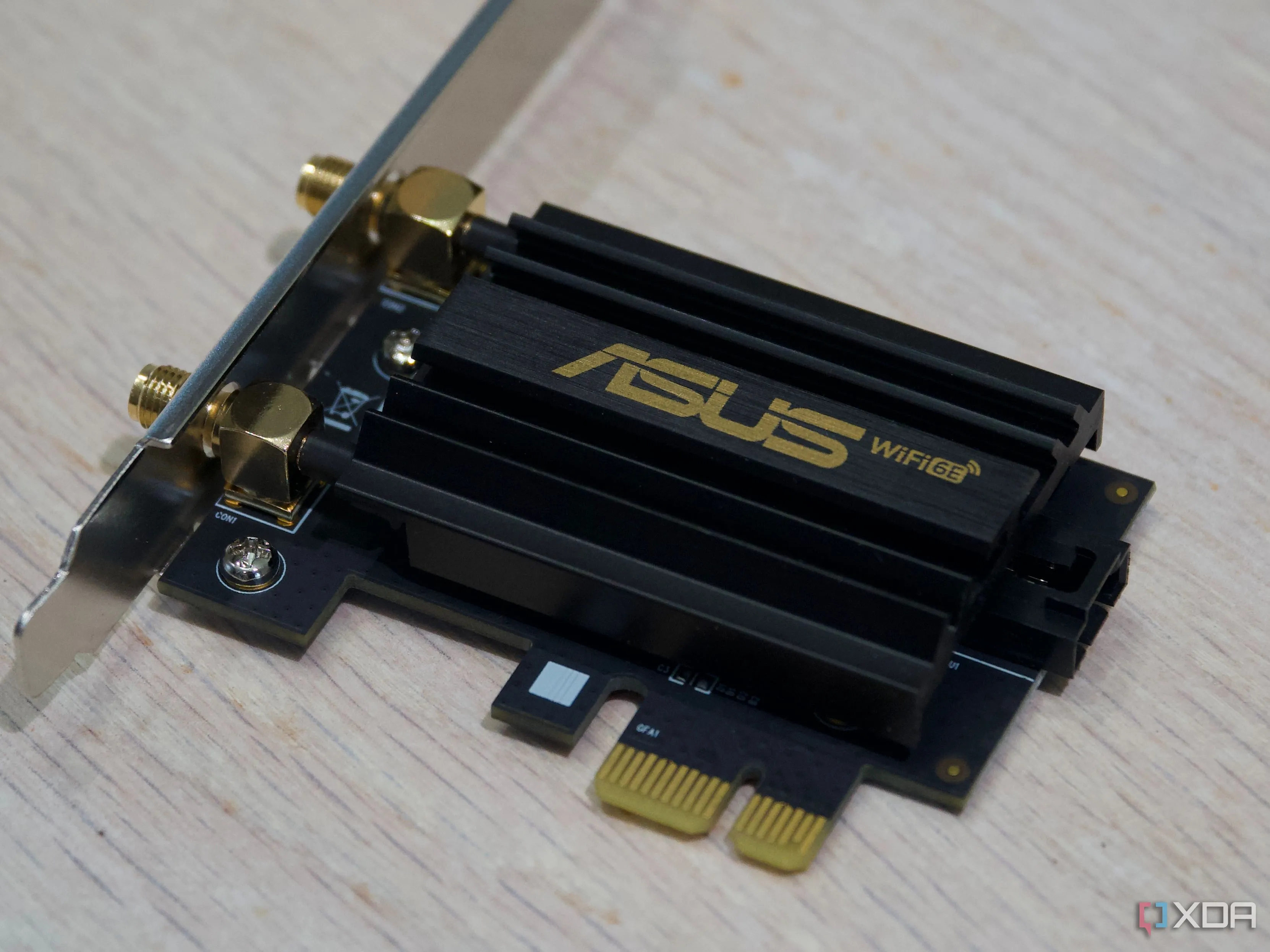 Bo mạch chủ của bộ chuyển đổi Wi-Fi ASUS PCE-AXE59BT chuẩn PCIe với tản nhiệt, minh họa linh kiện card Wi-Fi cho PC để bàn.