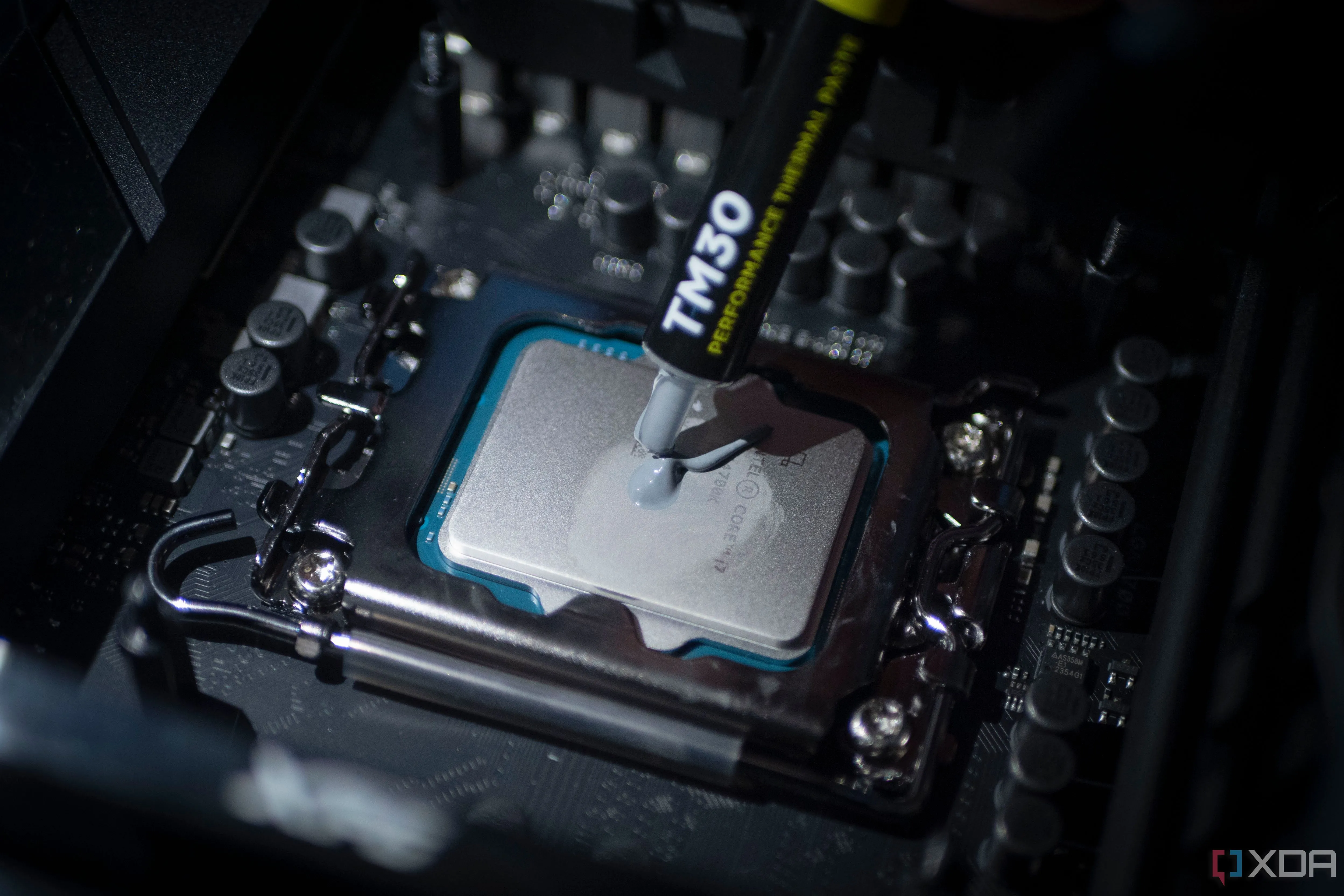 Bôi keo tản nhiệt lên chip Intel Core i7-14700K, minh họa quá trình bảo dưỡng cần thiết cho hệ thống làm mát.