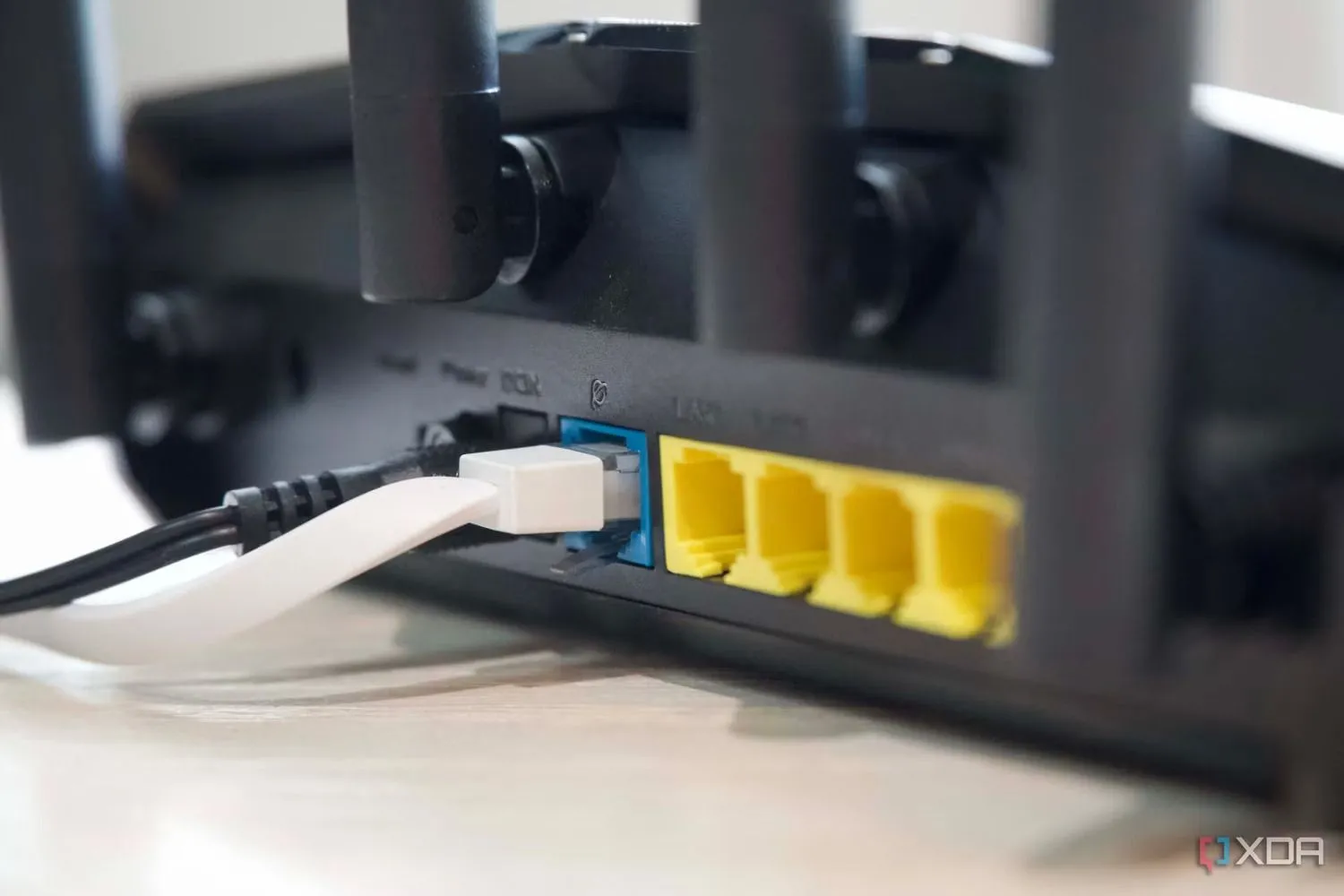 Cận cảnh các cổng Ethernet và ăng-ten của bộ định tuyến Asus RT-AX57, minh họa thiết bị mạng cho kết nối internet.