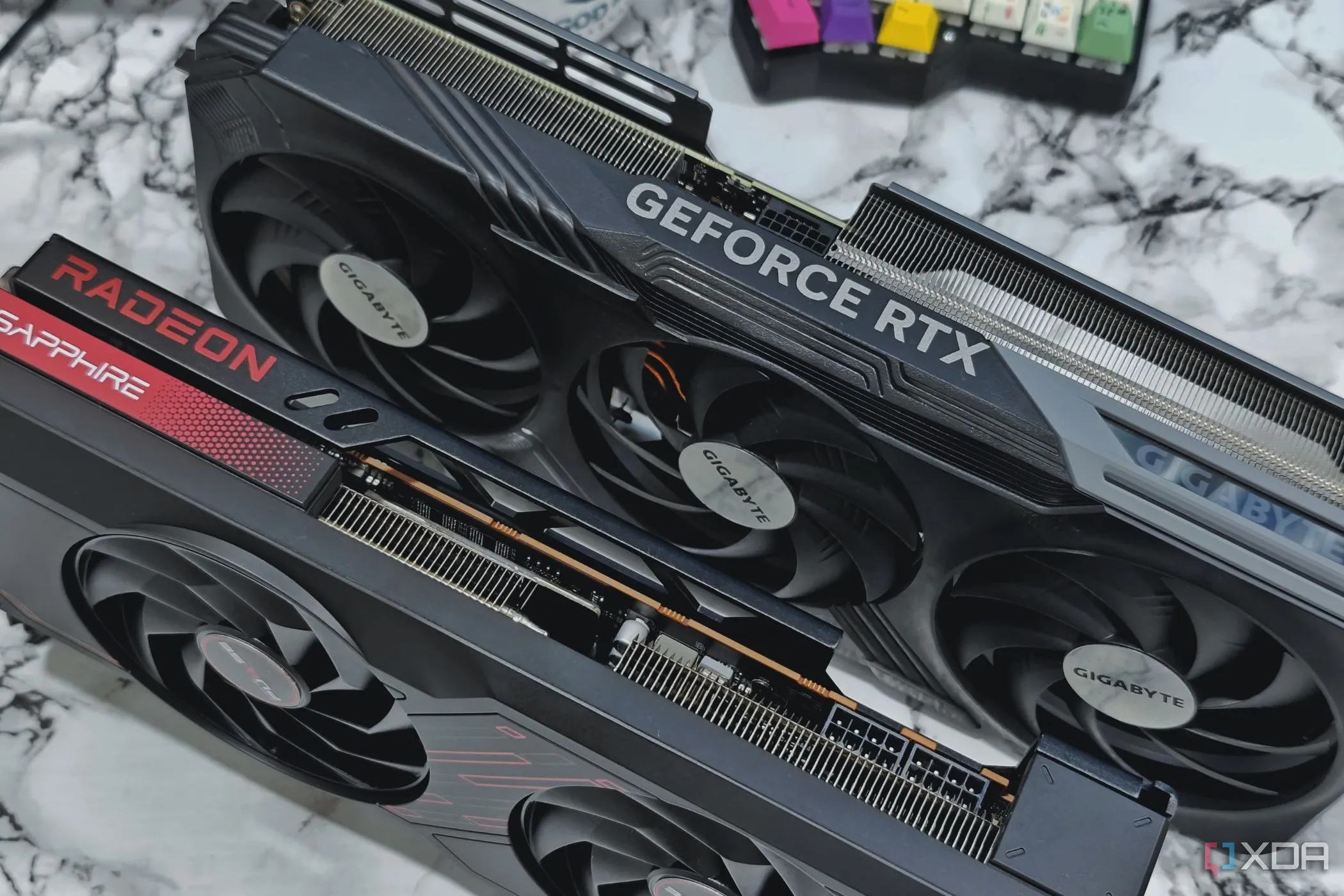 Card đồ họa GeForce RTX 4070 Ti và Radeon RX 7700 XT trên bàn phím chia đôi, minh họa sức mạnh GPU hiện đại