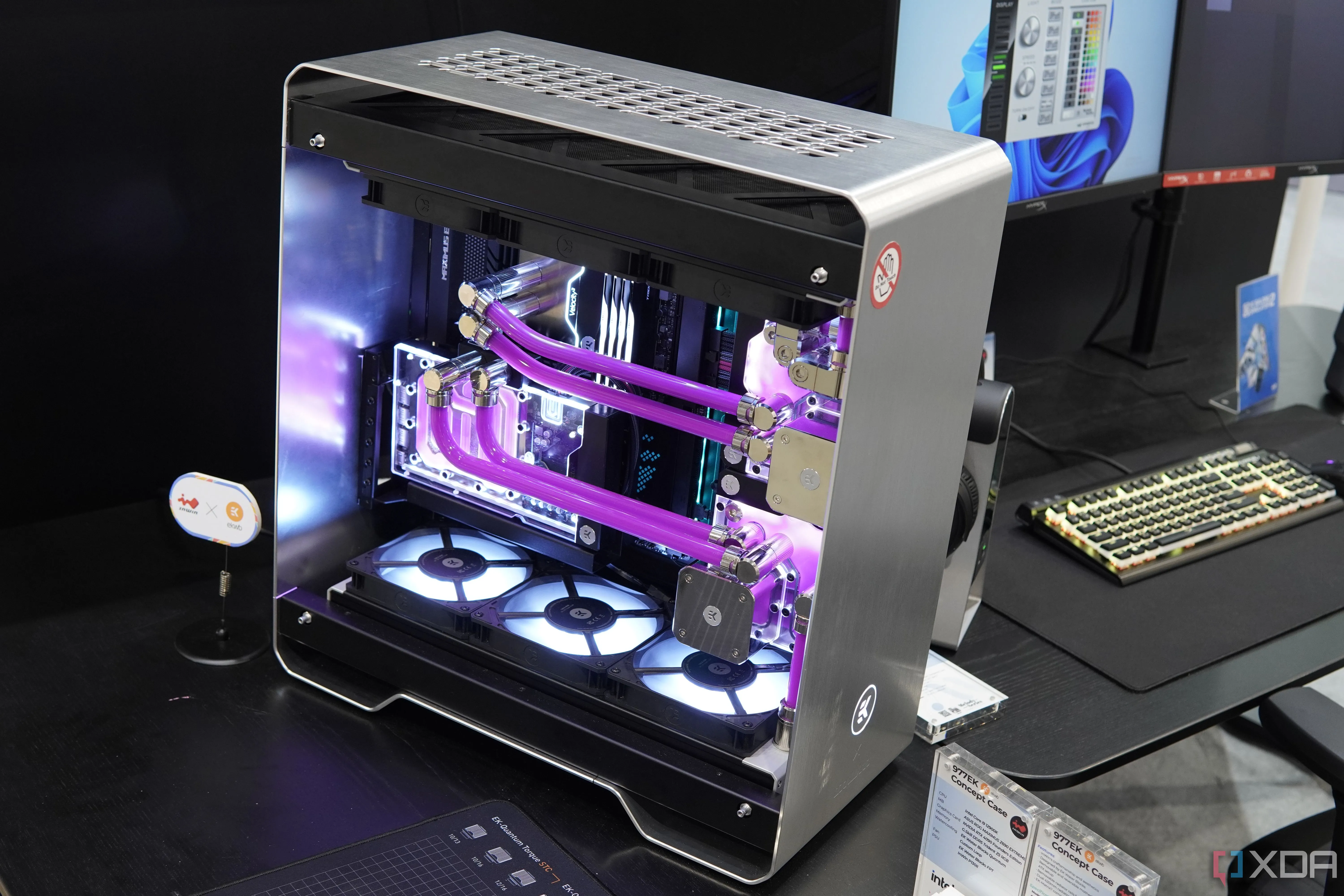 Chiếc PC tùy chỉnh InWin 977EK với vỏ kim loại bạc và hệ thống tản nhiệt nước màu hồng, thể hiện sự tỉ mỉ trong lắp ráp máy tính