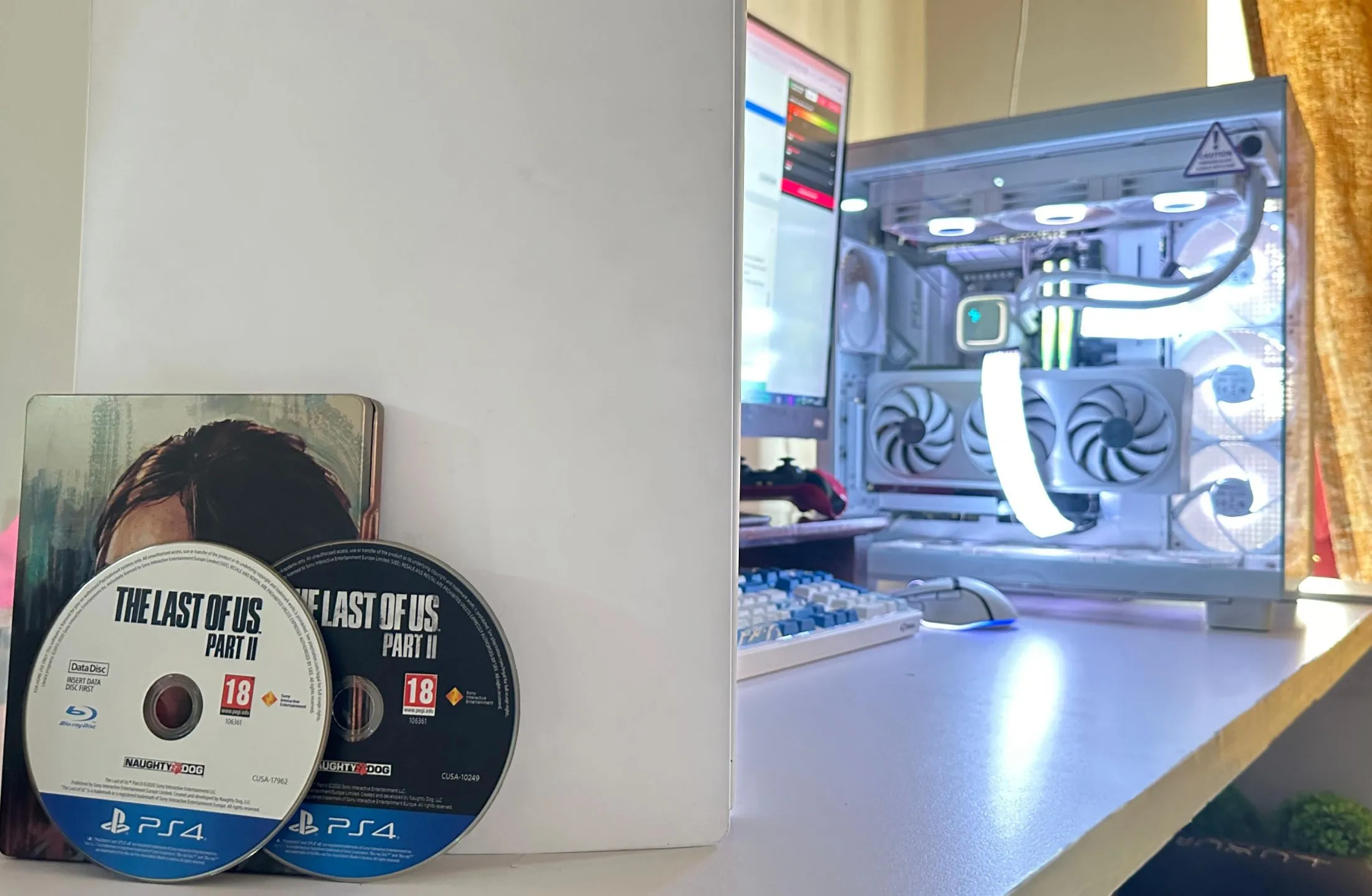 Hai đĩa game The Last of Us Part II phiên bản PS4 cùng với PC và PS5, thể hiện kích thước game ngày càng lớn.