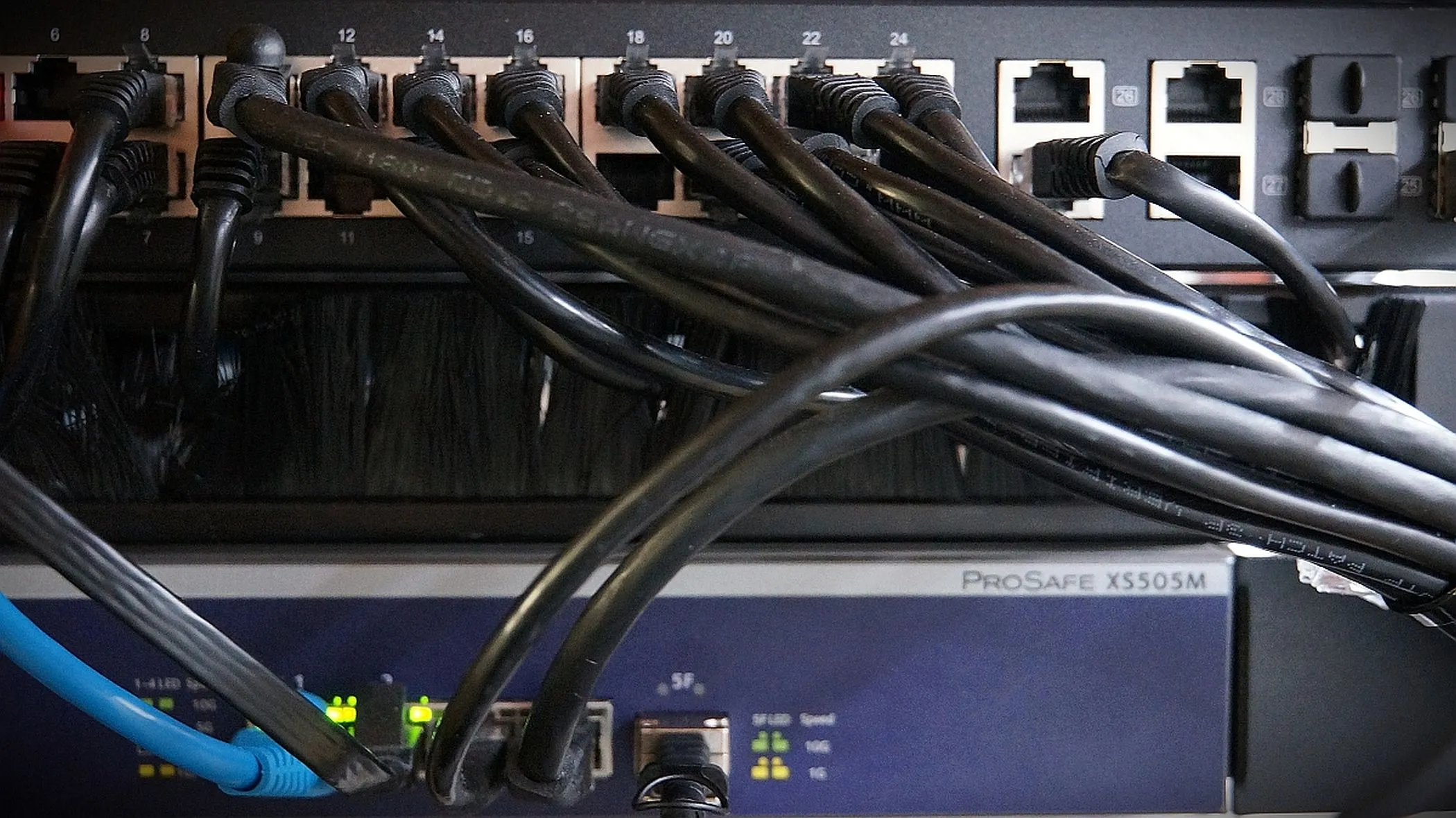 Hệ thống dây cáp Cat6a kết nối các switch mạng, tượng trưng cho cấu hình VLAN trunking phức tạp