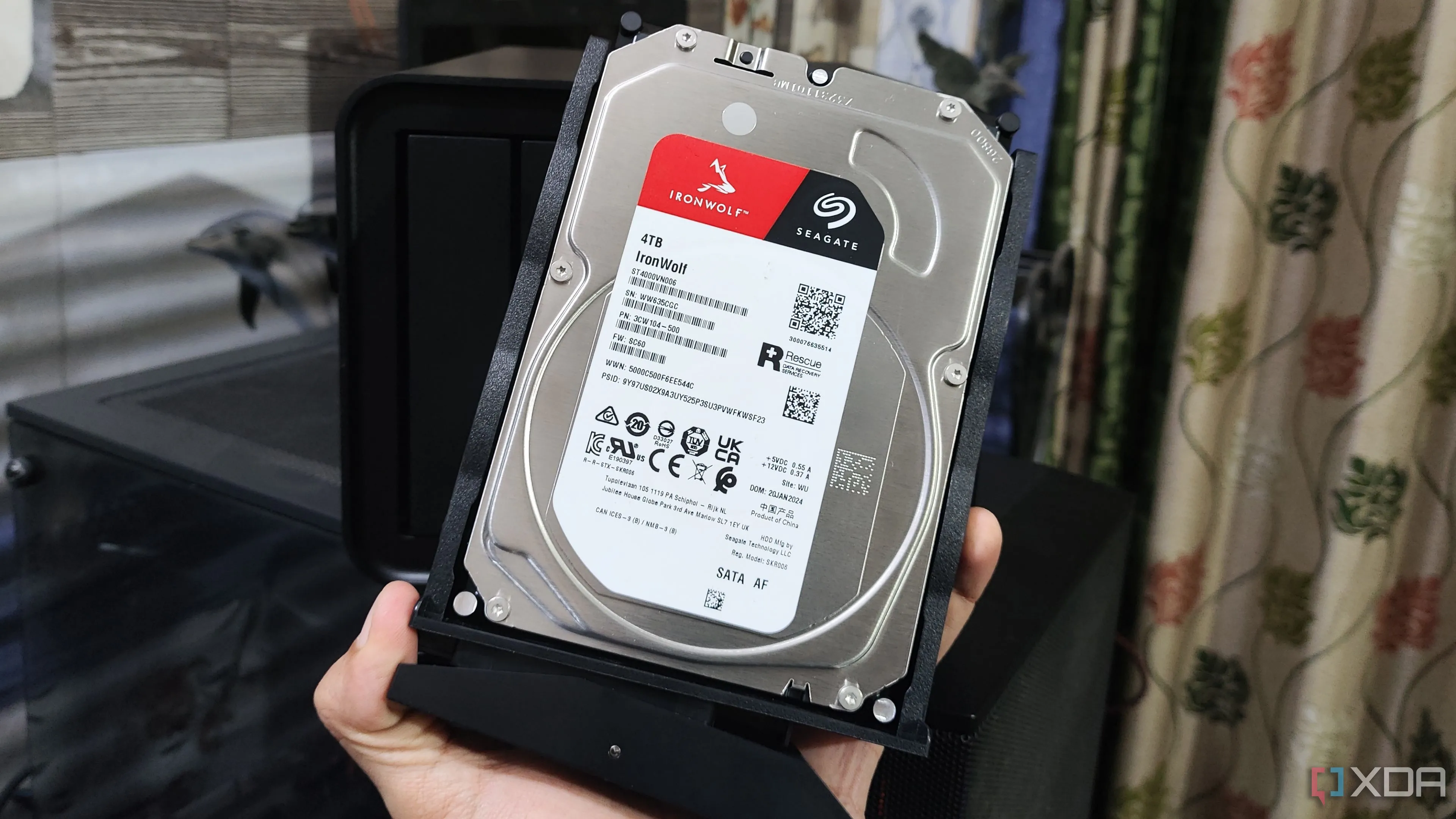 Hình ảnh minh họa một người đang cầm ổ cứng HDD Seagate, linh kiện thường gây chậm trễ khi tải game và ứng dụng trên PC cũ.