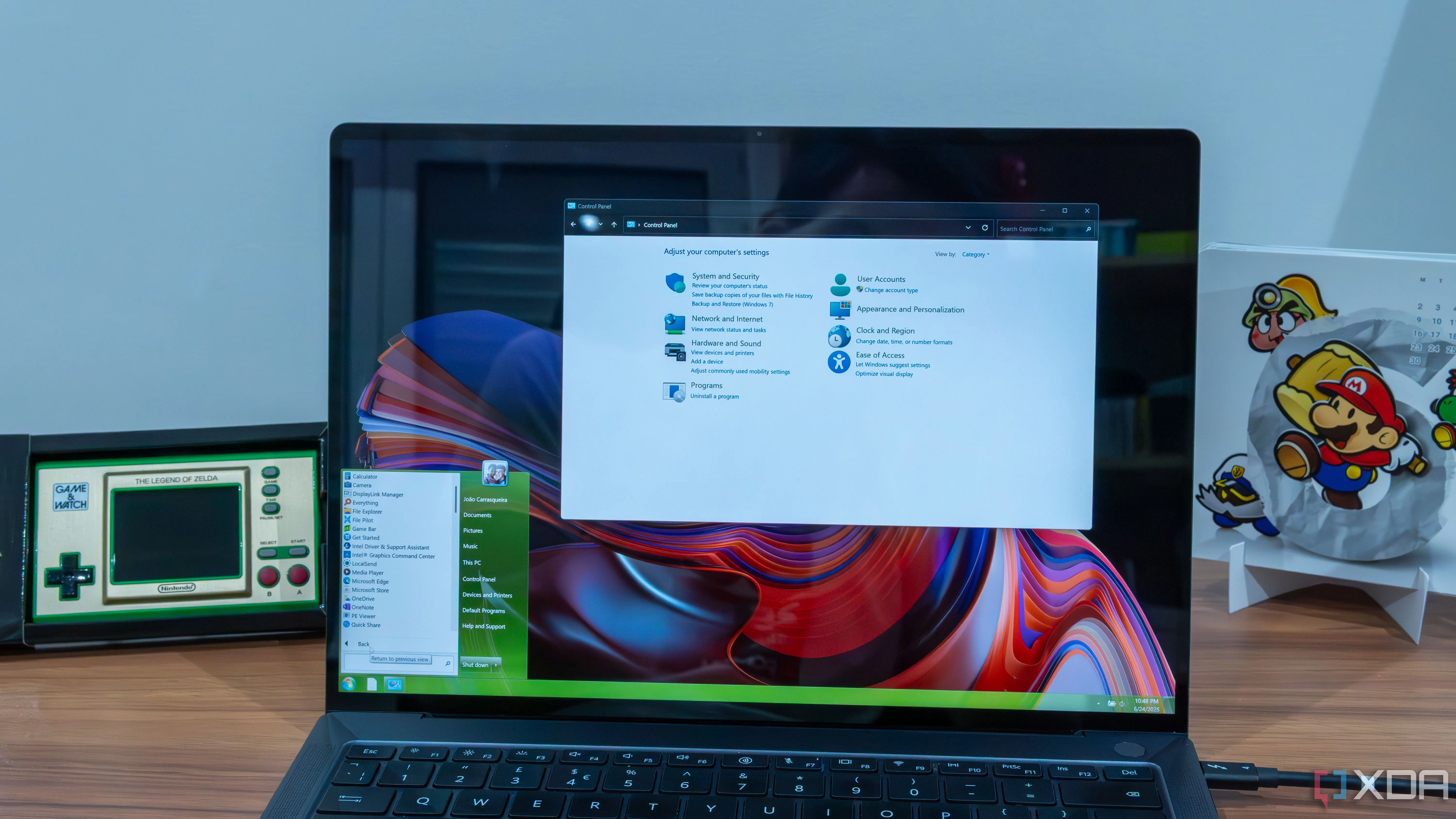Laptop chạy Windows 11 với Explorer 7 hiển thị thanh tác vụ và Start menu của Windows 7