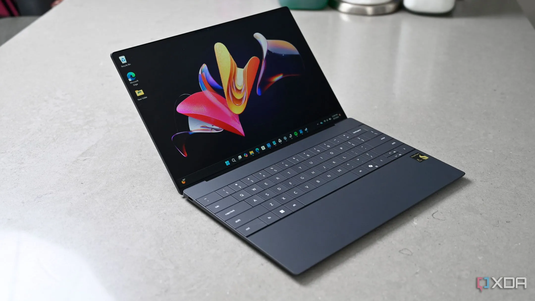 Laptop Dell XPS 9430 chạy Windows 11 đang mở một nửa, minh họa cho các tính năng mới của hệ điều hành.