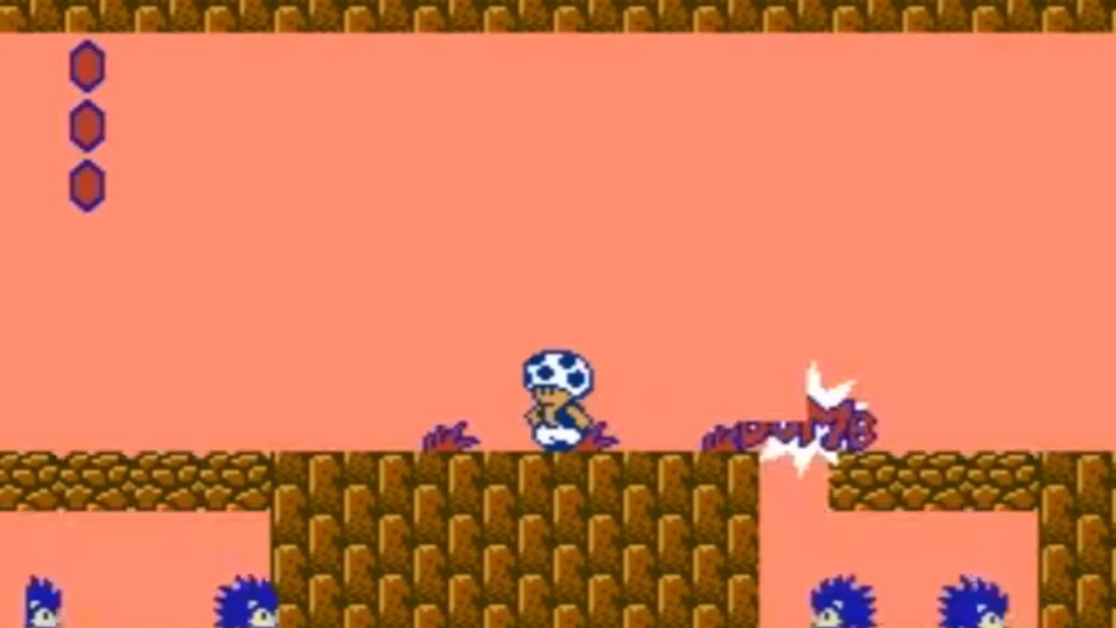 Mario đứng trên một nền tảng trong Super Mario Bros 2 với cảnh núi và hầm ngục