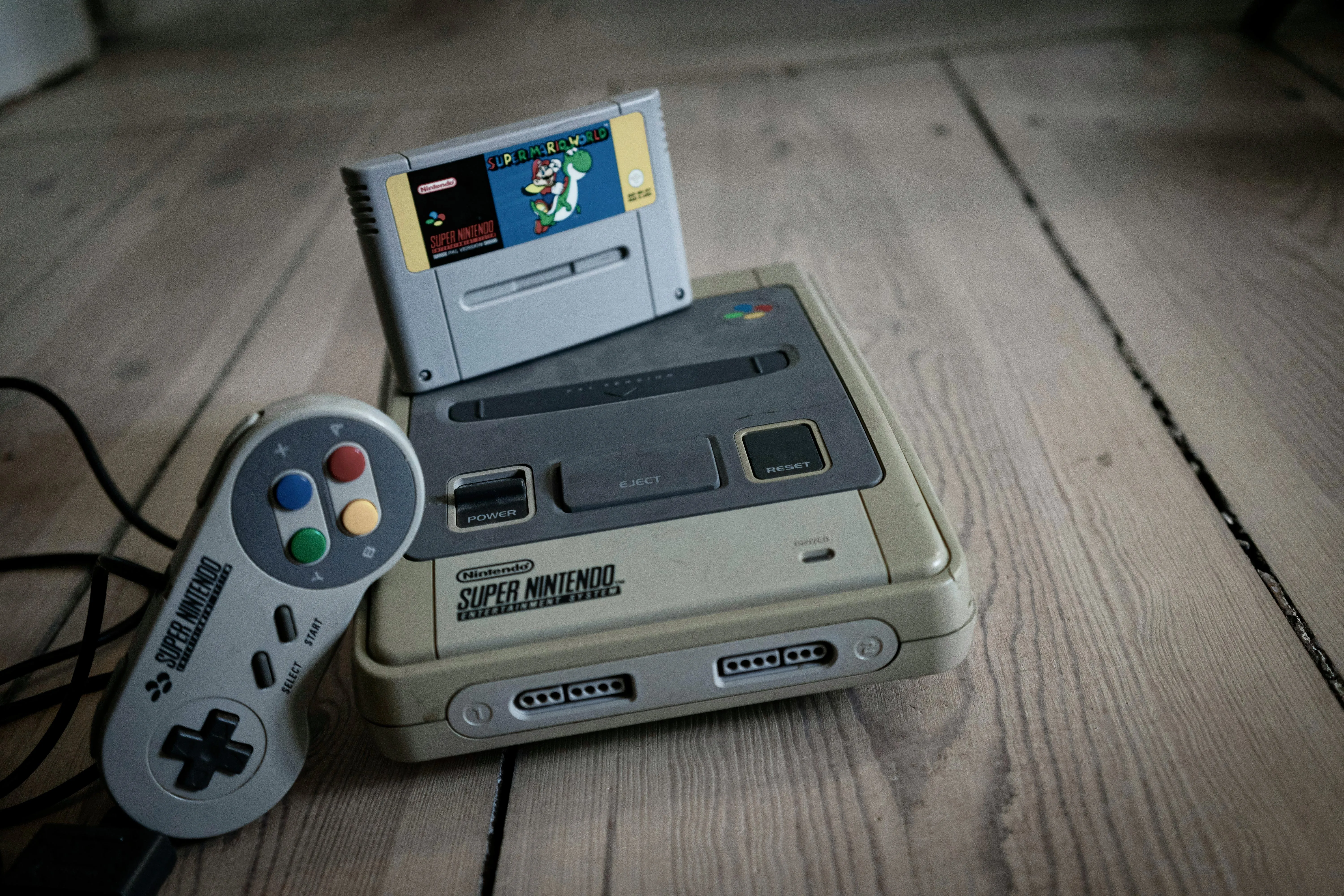 Máy chơi game Super Nintendo Entertainment System (SNES) và tay cầm đặc trưng, kế nhiệm thành công của NES.