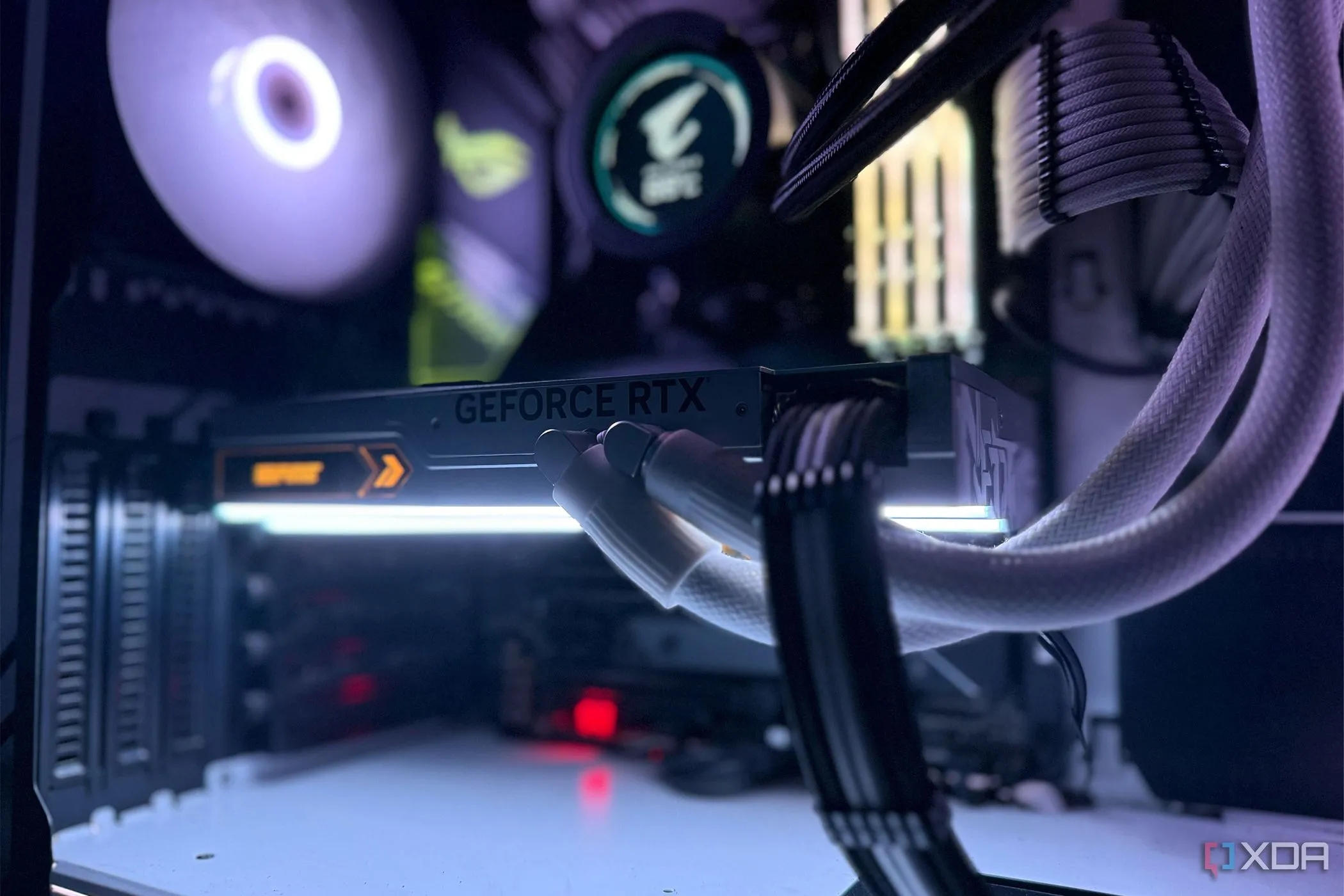 Một chiếc card đồ họa NVIDIA GeForce RTX 4090 màu trắng được lắp đặt bên trong một case máy tính chơi game, tỏa sáng với đèn LED RGB