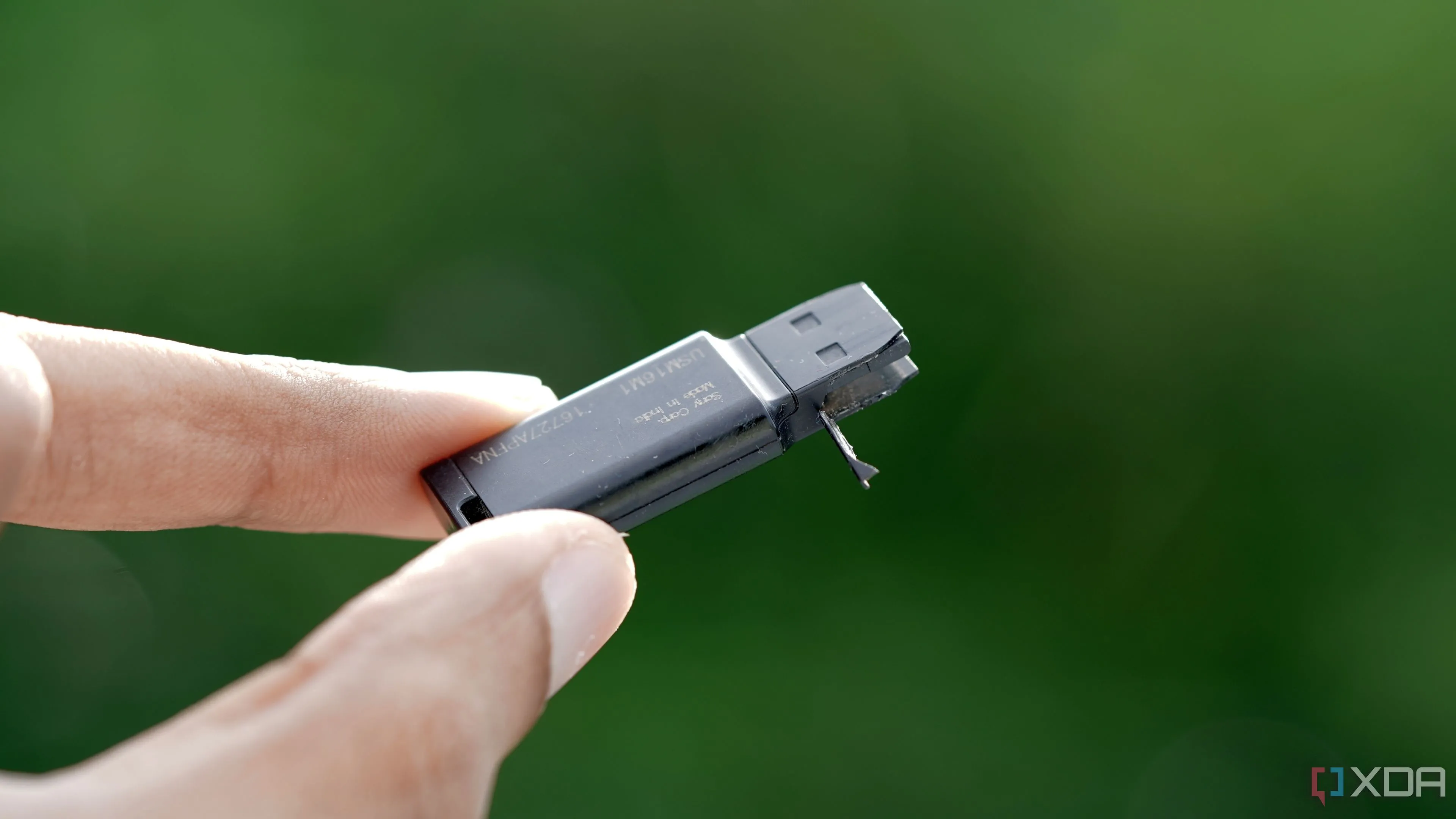 Một chiếc USB flash drive Sony 16GB màu đen bị mòn và hư hại, minh họa độ bền kém của USB truyền thống