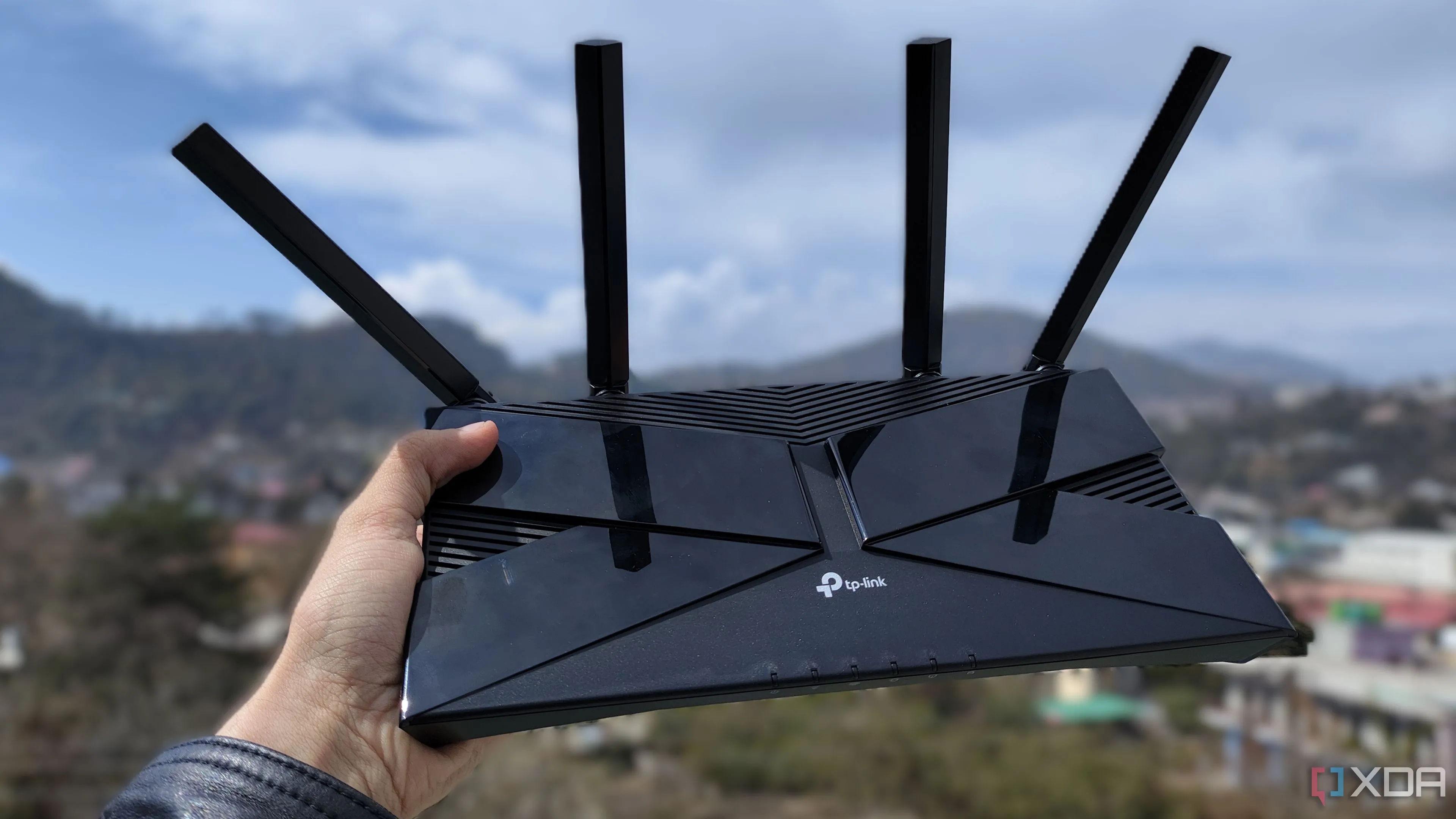Một người đàn ông đang cầm bộ định tuyến (router) TP-Link, tượng trưng cho router phổ biến mà các nhà cung cấp dịch vụ Internet thường trang bị cho người dùng.