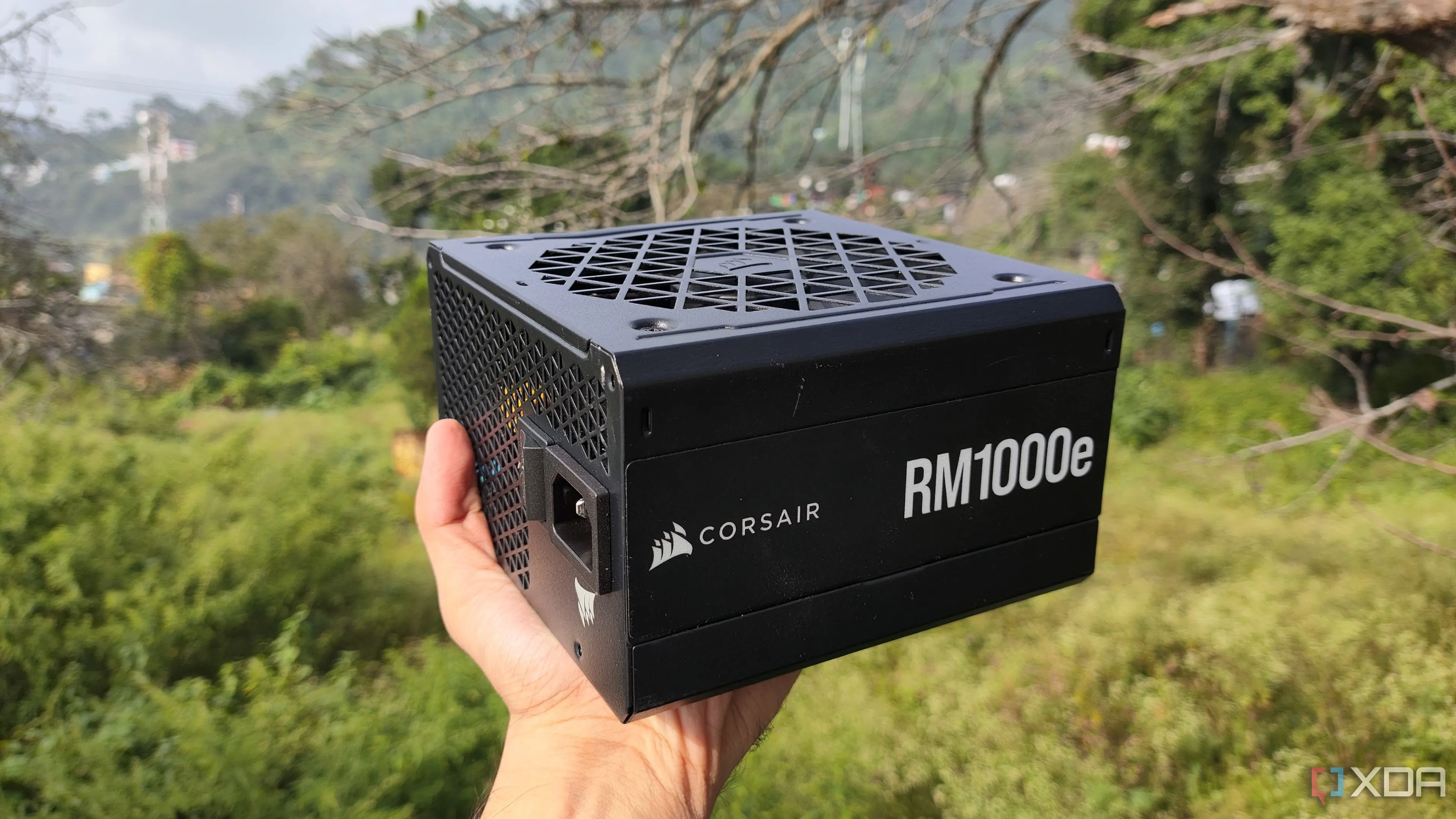 Một người đang cầm bộ nguồn Corsair RM1000e PSU, thành phần quan trọng cung cấp năng lượng cho PC