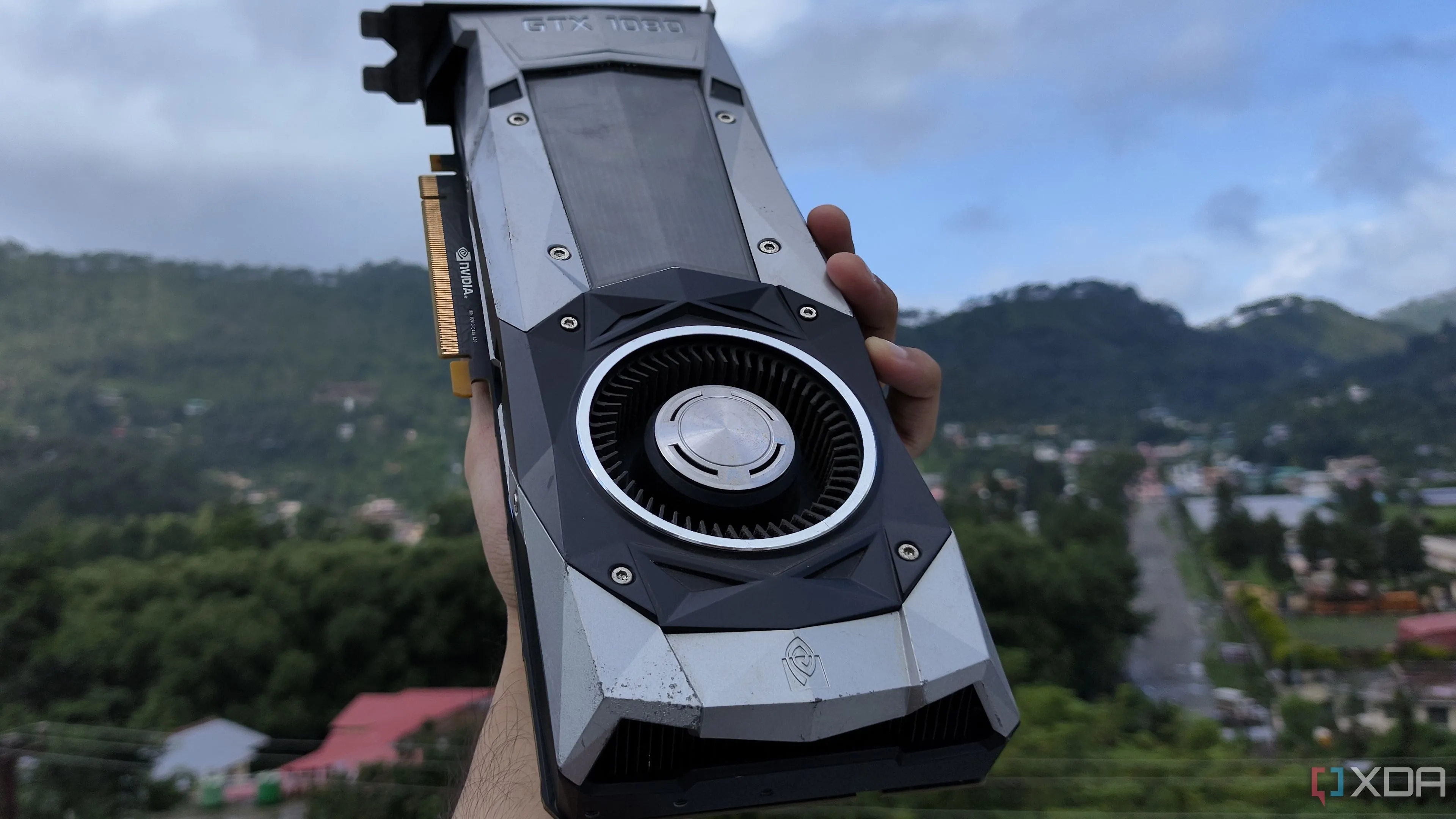 Một người đang cầm card đồ họa NVIDIA GeForce GTX 1080 Founders Edition, biểu tượng cho linh kiện PC có tuổi thọ bền bỉ.