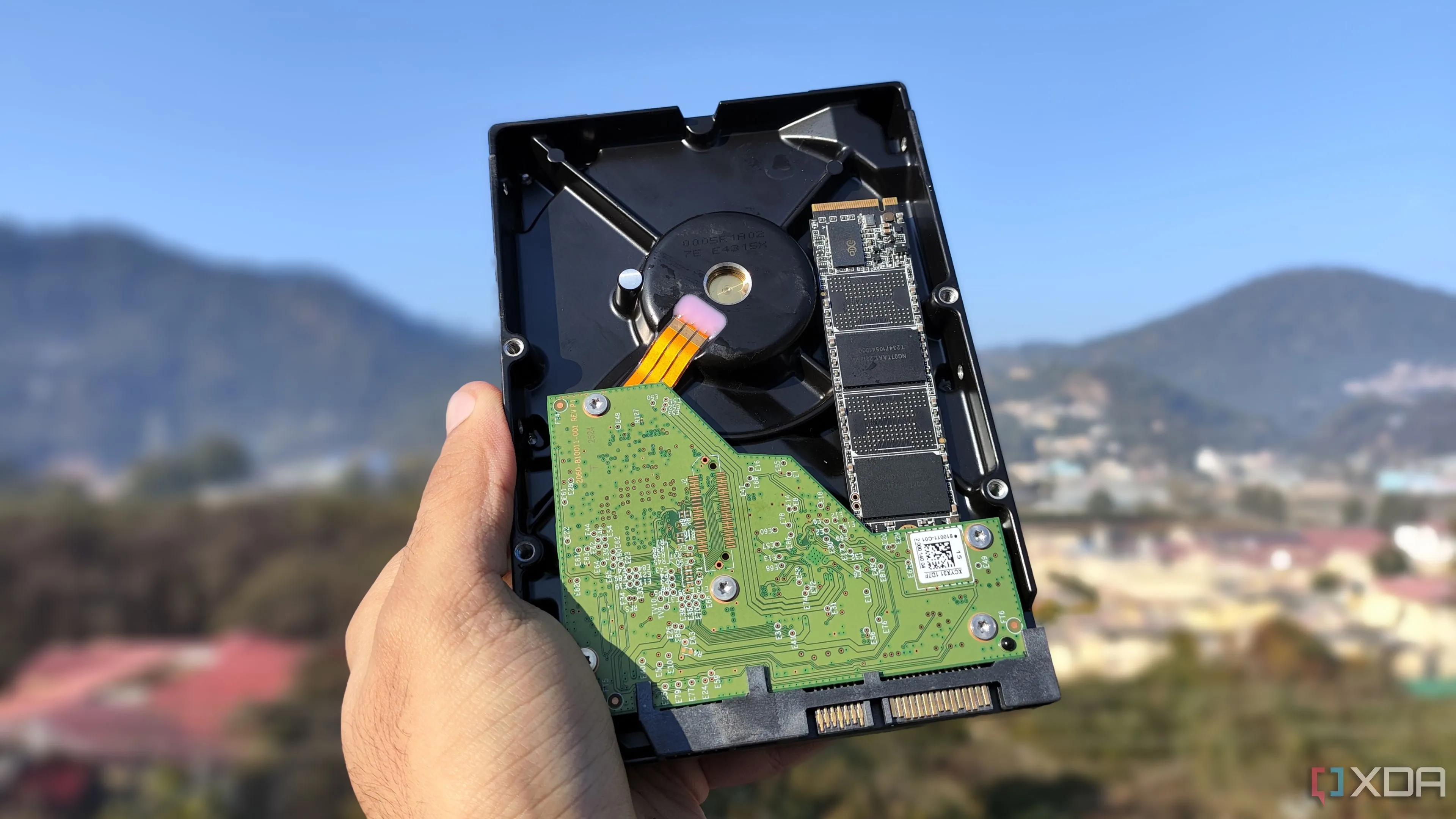 Một người đang cầm ổ cứng HDD và SSD