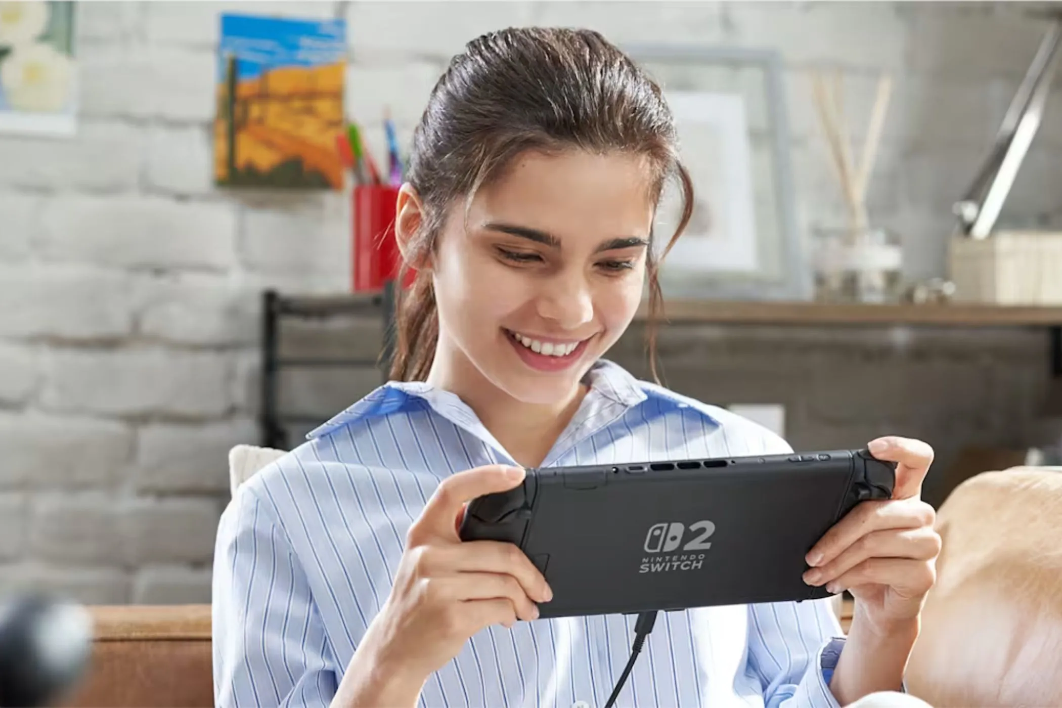 Người chơi đang cầm trên tay máy chơi game Nintendo Switch 2 ở chế độ cầm tay, thể hiện sự tiện lợi và di động