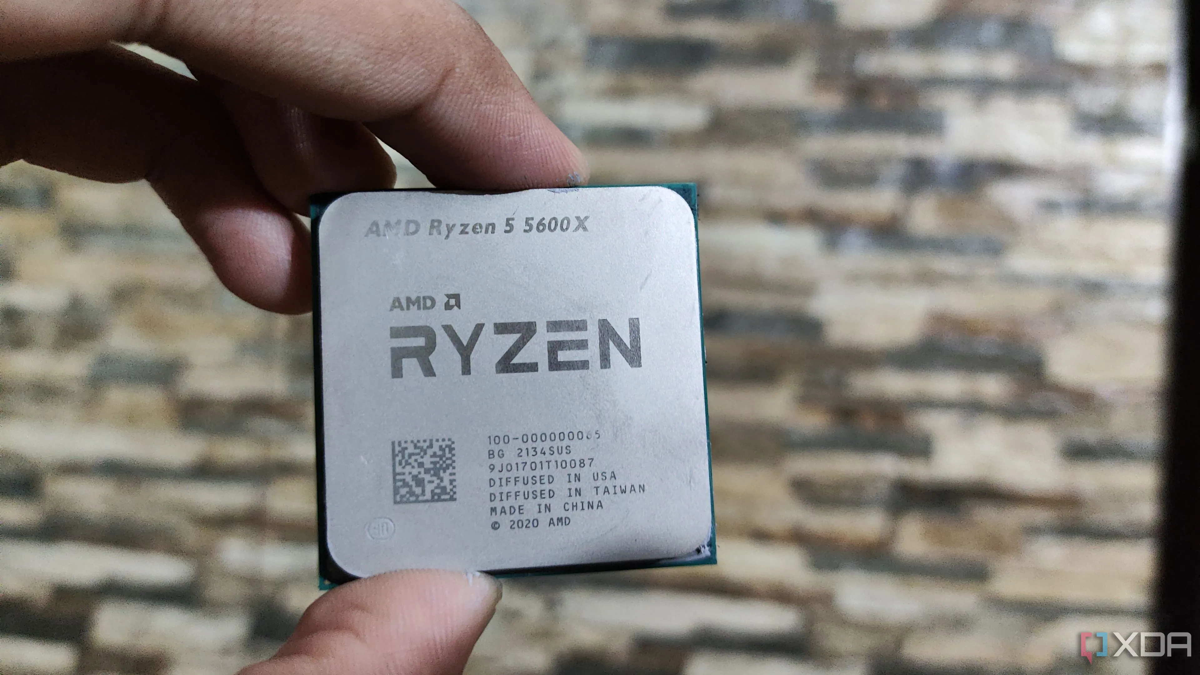 Người dùng đang cầm bộ vi xử lý AMD Ryzen 5 5600X, tượng trưng cho quá trình nâng cấp linh kiện PC