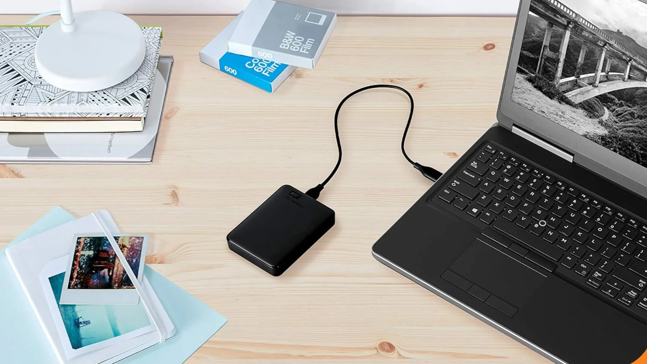 Ổ cứng di động WD 5TB kết nối laptop trên bàn làm việc, minh họa cho việc sao lưu cục bộ