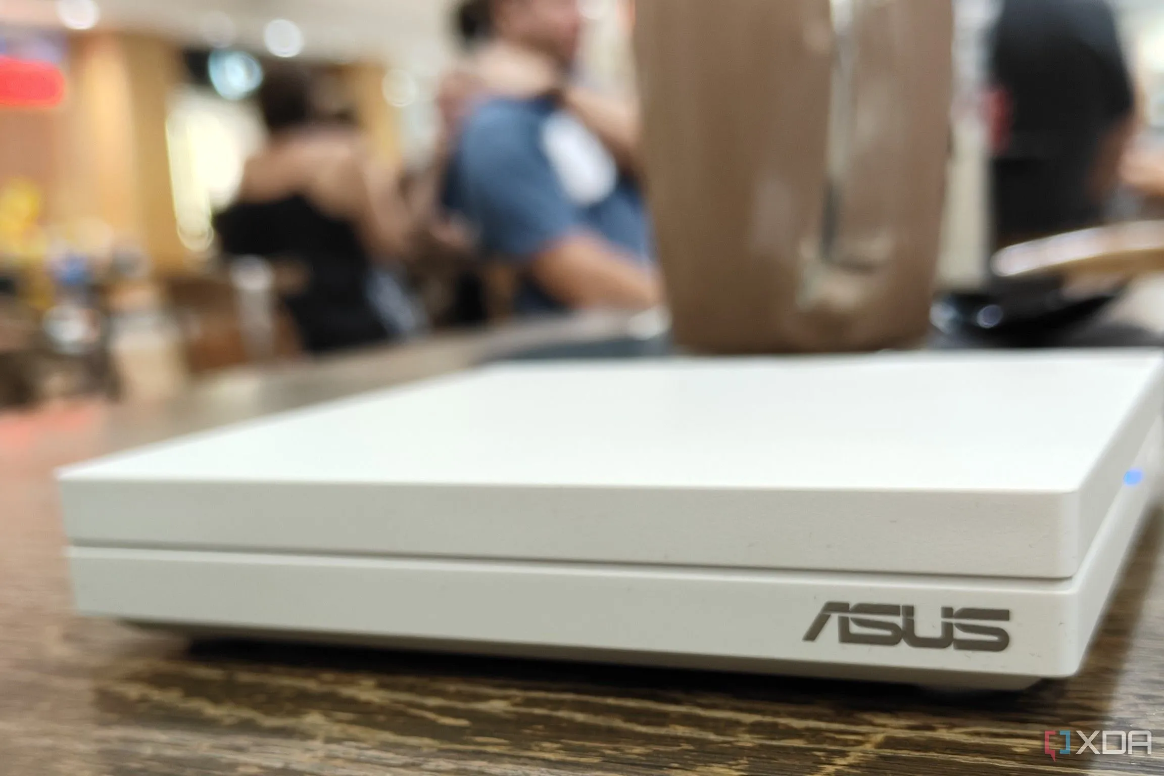 Router du lịch đặt trên bàn tại sân bay, tượng trưng cho các cài đặt nâng cao của router