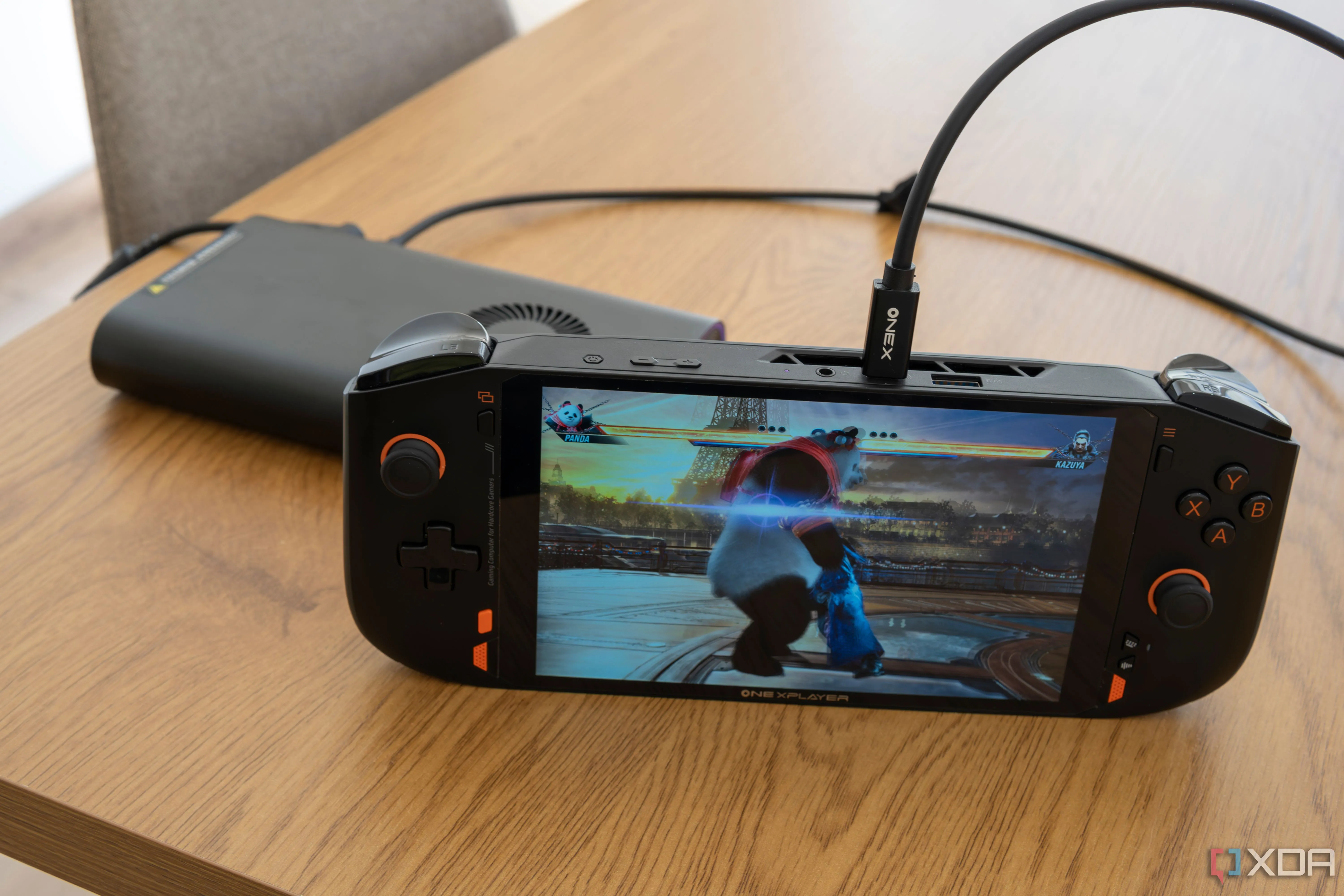 Thiết bị chơi game cầm tay One XPlayer Mini Pro chạy Tekken 8, kết nối với bộ eGPU OneXGPU, thể hiện khả năng nâng cấp hiệu năng gaming.