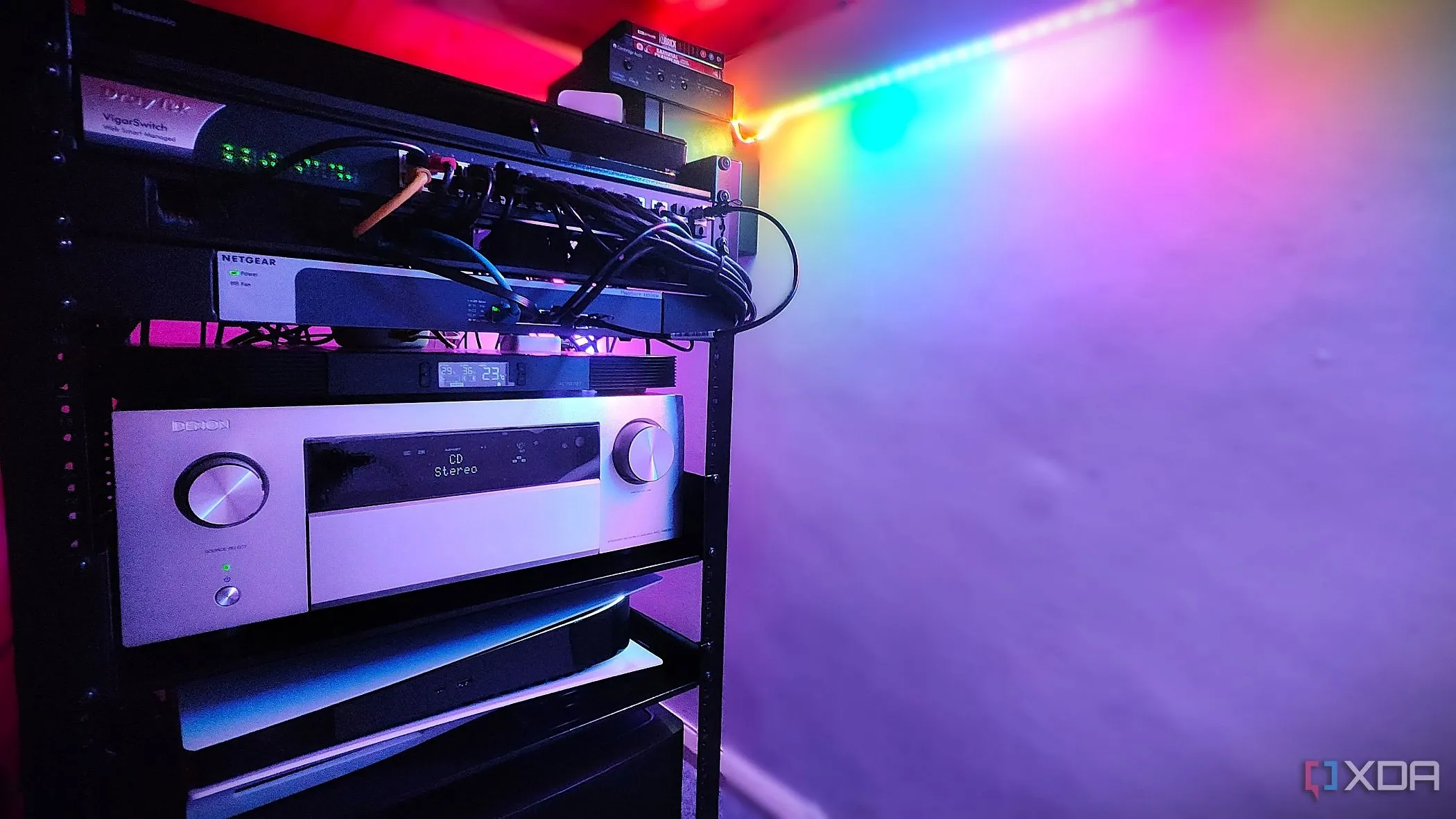 Tủ rack chứa các thiết bị âm thanh, video như Denon AVR, PS5 và nhiều switch mạng, tối ưu không gian và quản lý cáp