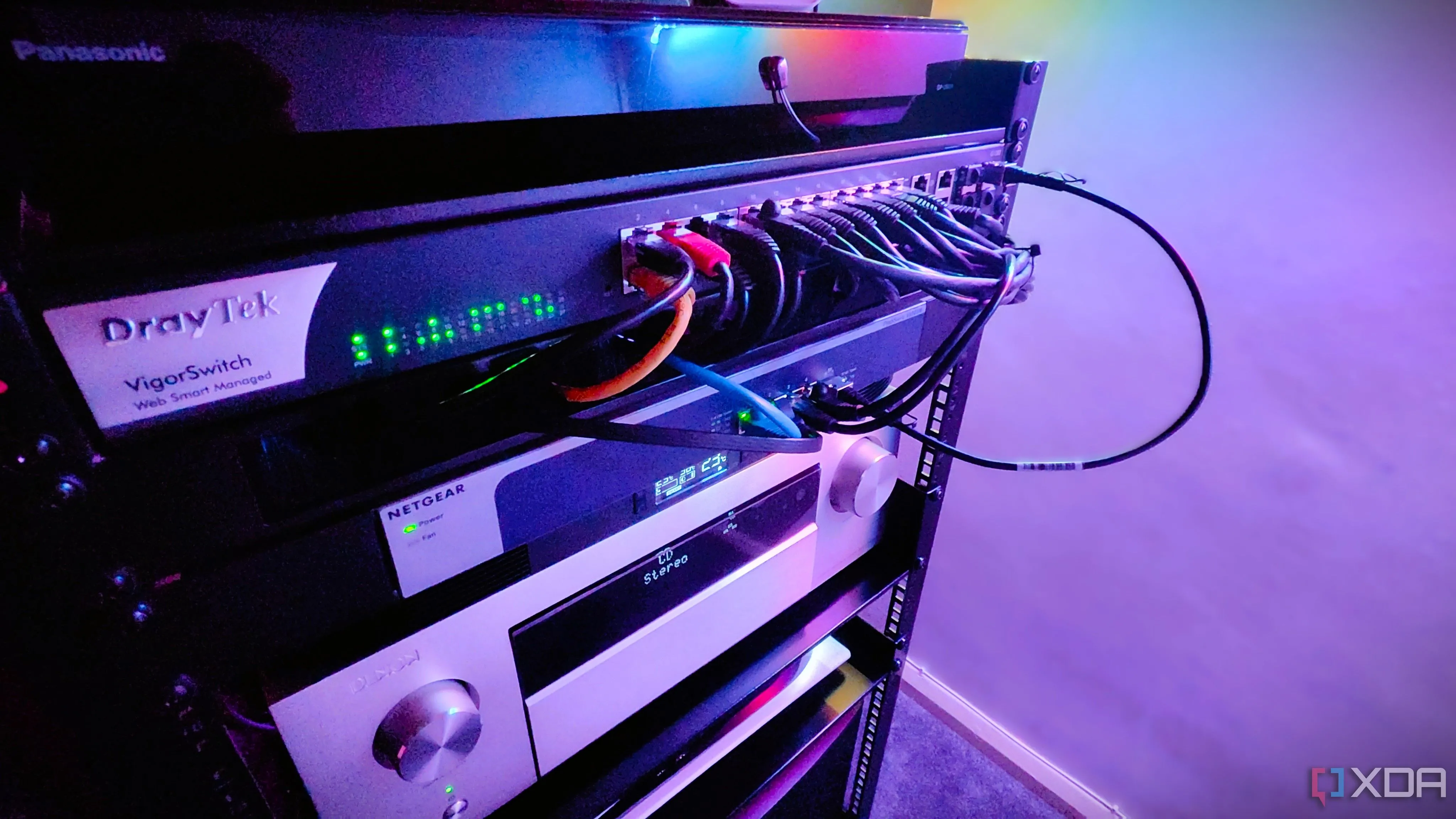 Tủ rack mạng với nhiều switch và thiết bị A/V, thể hiện khả năng mở rộng của hạ tầng mạng gia đình hiện đại